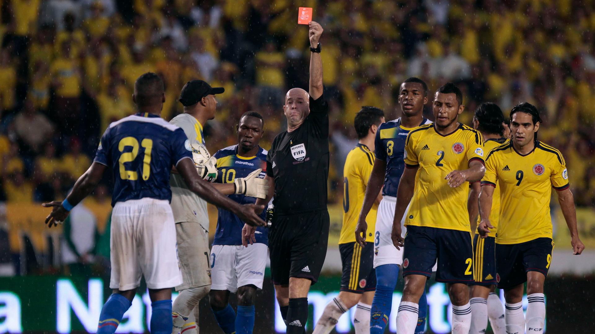 FIFA referee shows a red card during a 2014 World Cup qualifying match between Ecuador and Colombia
