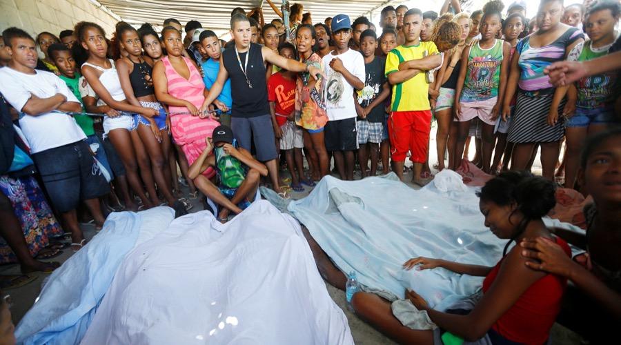 Residents gather round the bodies of suspected drug traffickers in the City of God favela in Rio de Janeiro on Nov. 20.