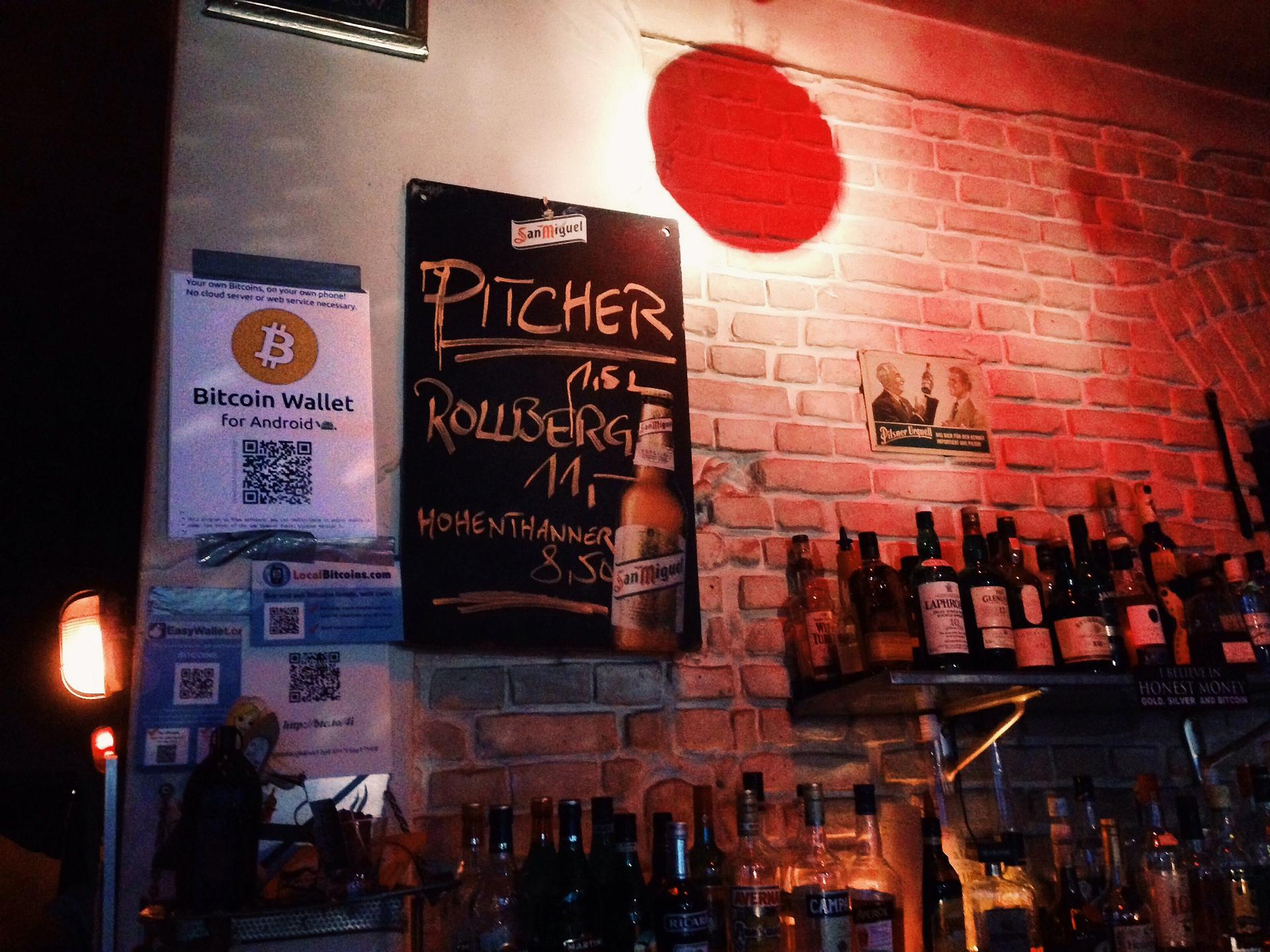 Behind the bar at Room 77 a sign announces that clients can pay for their beers in Bitcoin.