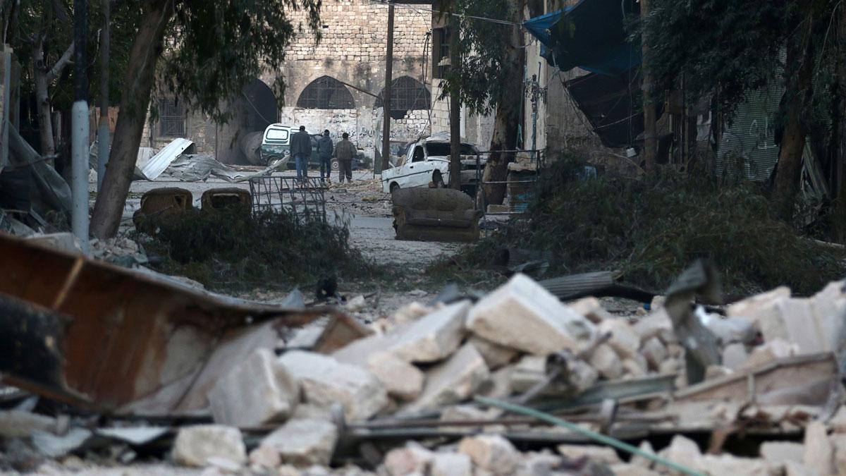 People walk near rubble of damaged buildings, in the rebel-held besieged area of Aleppo.