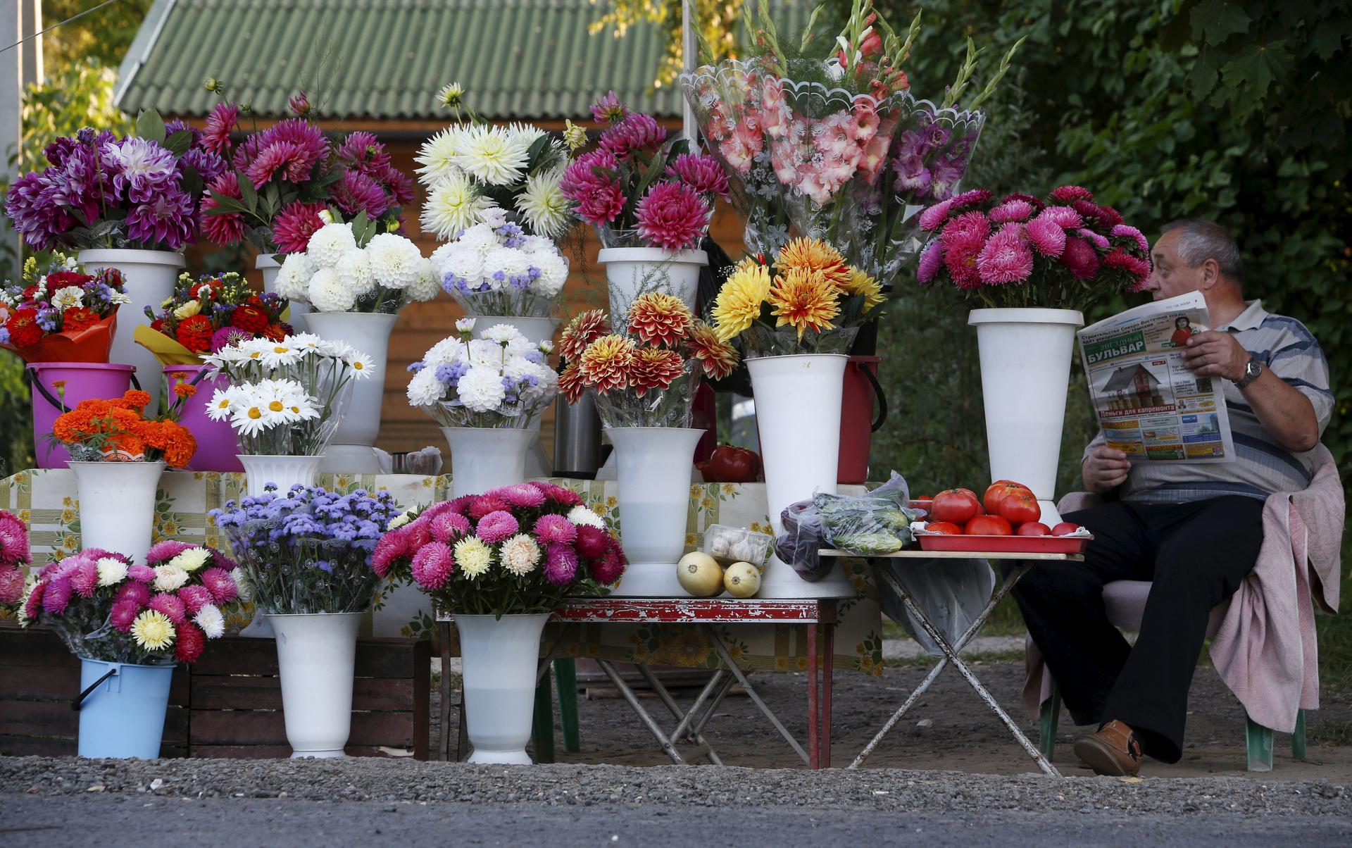 A street vendor sells flowers and vegetables on the roadside outside Moscow, Russia.