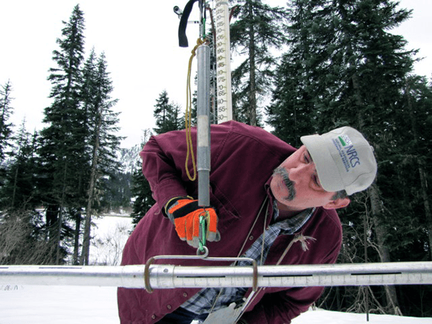 Scott Pattee, a water supply specialist with the National Resources Conservation Service, checks snow levels at Stevens Pass ski resort in Washington's Cascade Mountains. 