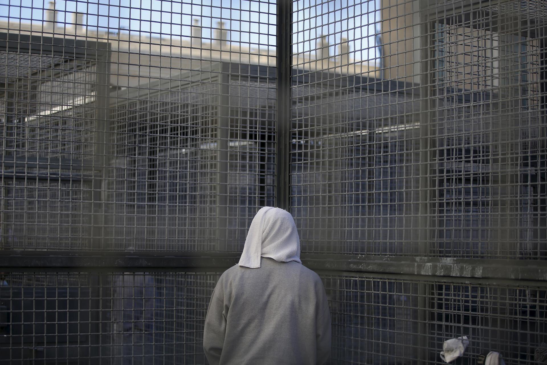 An inmate stands against a fence at the Adjustment Center yard during a media tour of California's death row at San Quentin State Prison, California, December 2015.