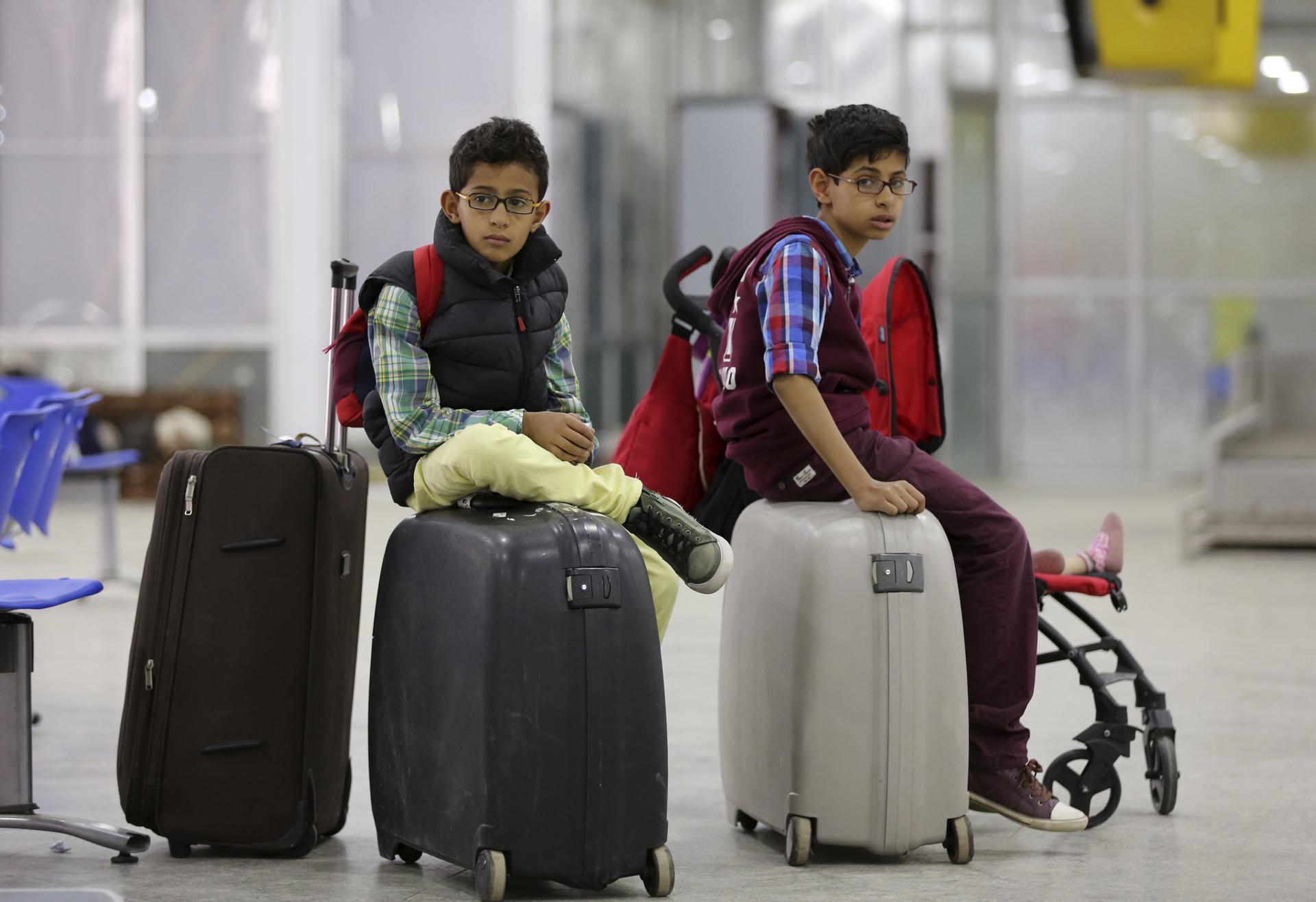 Boys wait for a flight at Sanaa International Airport, where foreigners are being evacuated from Yemen.