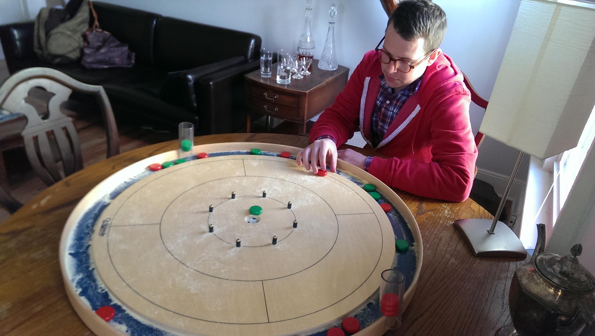 Scott Philipps and his roommate own three Crokinole boards. Each board is over two feet in diameter and takes up a tabletop. The one pictured here is a "regulation" board used for tournament play.