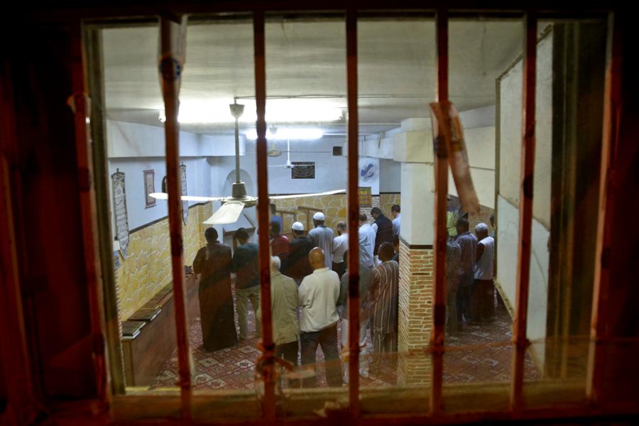 Muslim men gathered in a basement transformed into a a prayer room in the neighborhood of Agios Nikolaos, in Athens