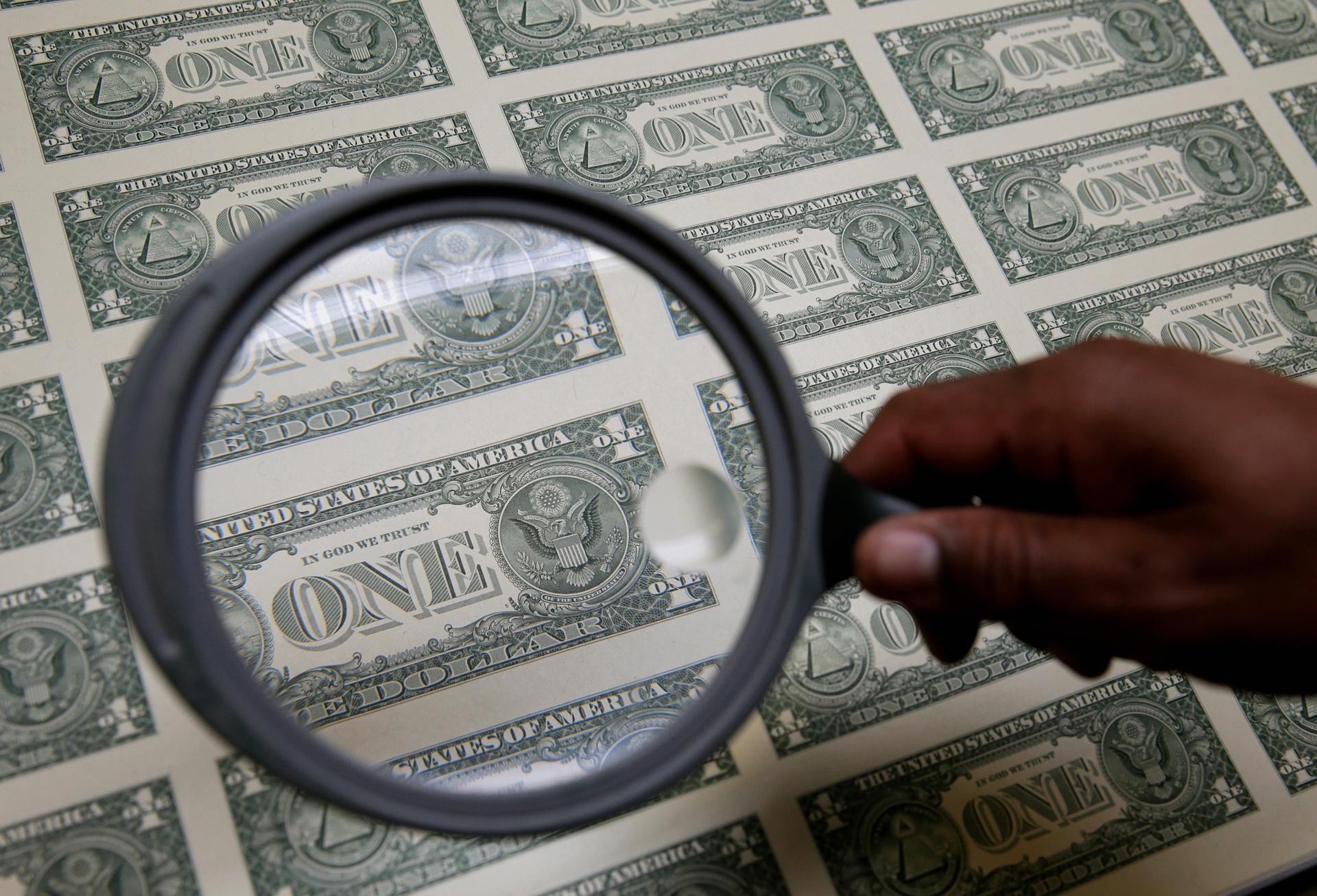 Dollar bills and a magnifying glass
