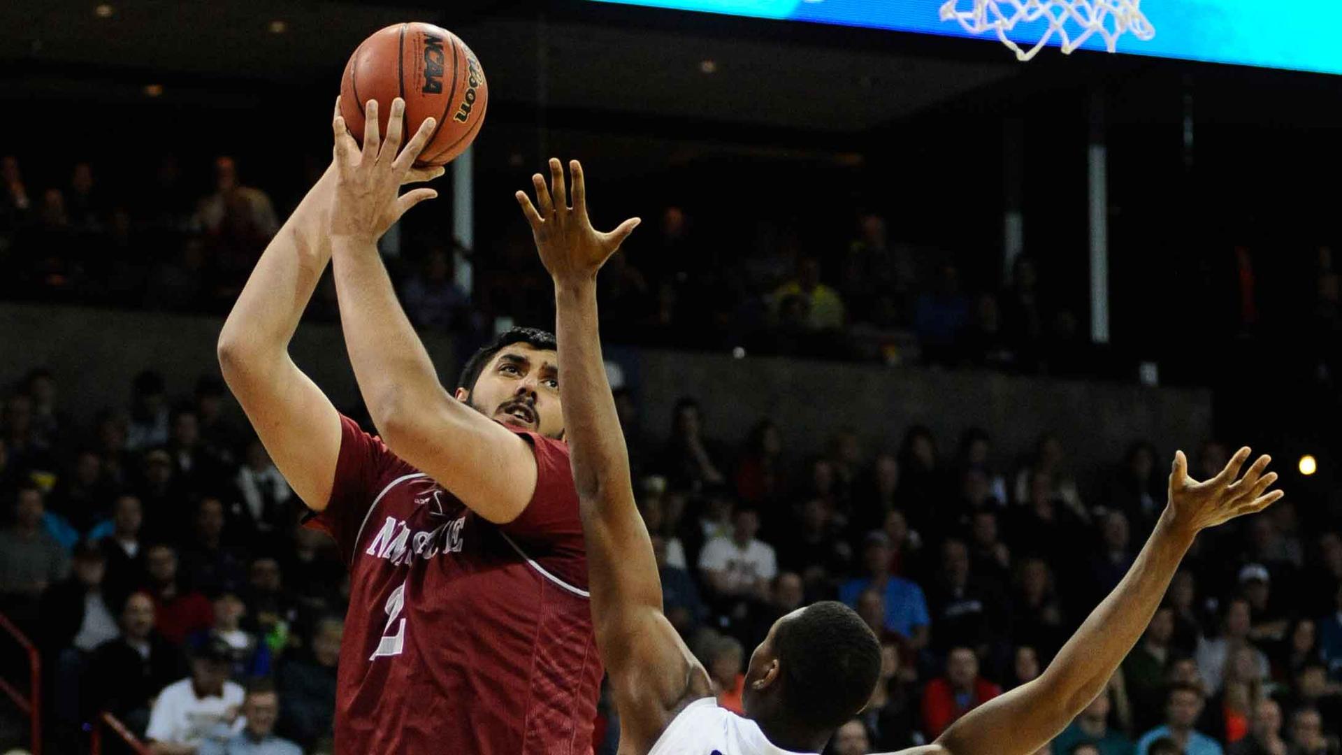 Sim Bhullar playing for the New Mexico State Aggies during the 2014 NCAA Tournament. Bhullar signed a 10-day contract with the Sacramento Kings in 2015, becoming the first player of Indian descent in the league.