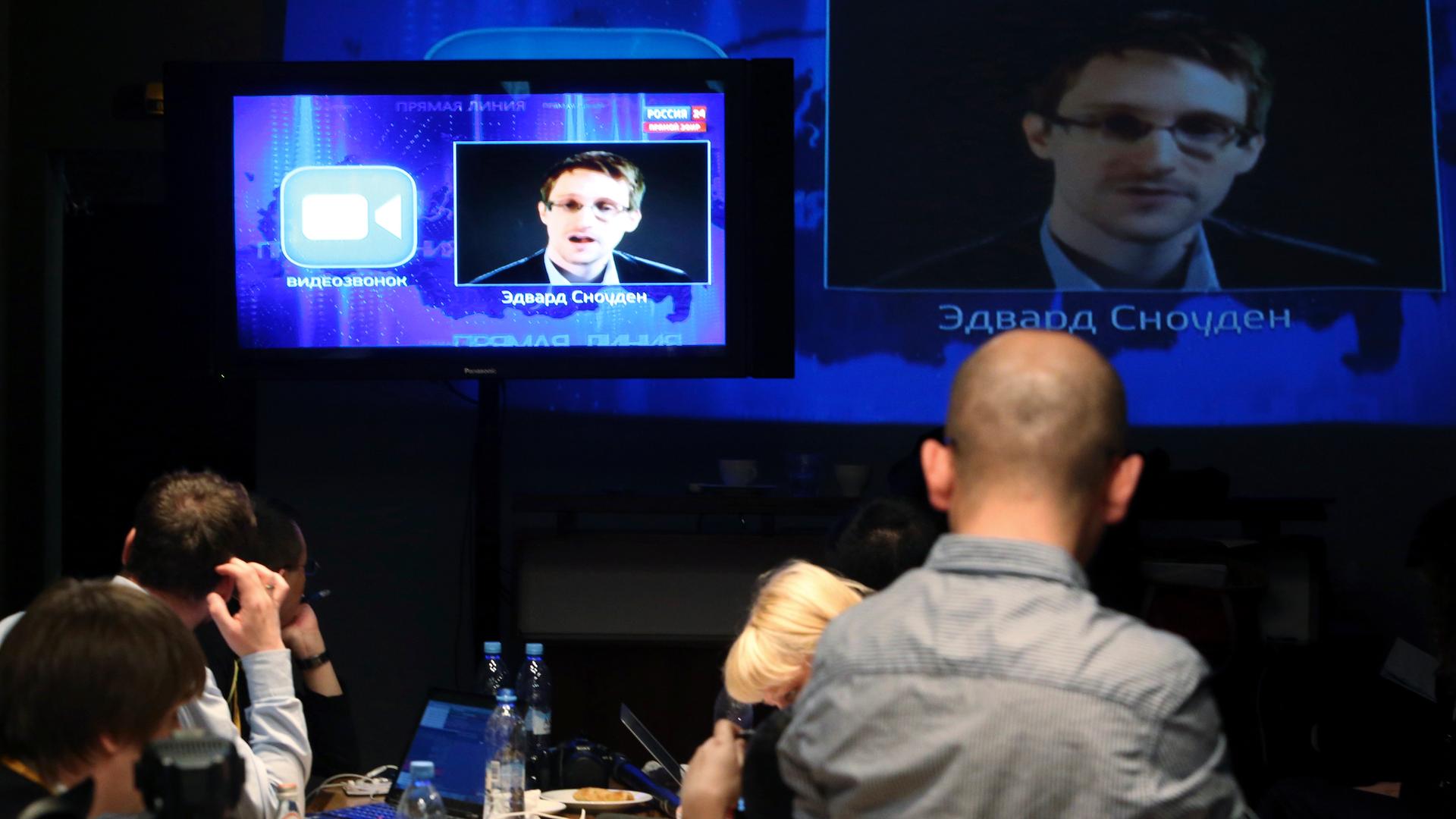 Journalists listen to a question posed by former US spy agency NSA contractor Edward Snowden, at a media center during Russian President Vladimir Putin's live broadcast nationwide phone-in.