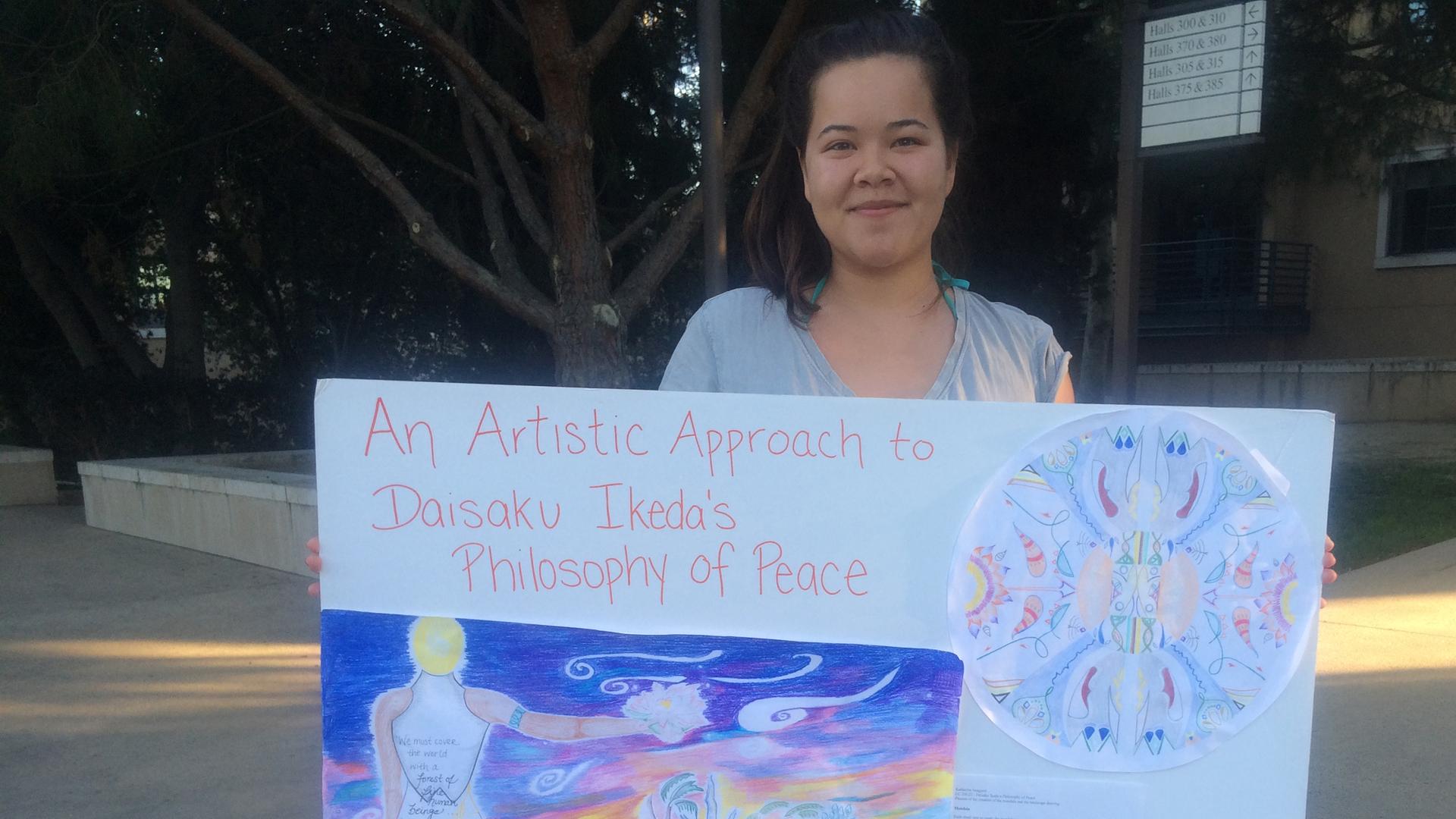 Katie Iwagami displays the poster she did for a research seminar on Soka University founder Daisaku Ikeda’s philosophies of peace.