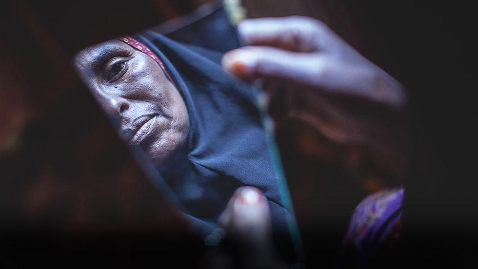 A woman looks into a piece of a mirror in Hargeysa, Somalia.