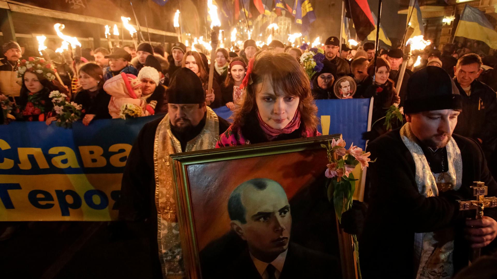 Activists of the Svoboda (Freedom) Ukrainian nationalist party hold torches as they take part in a rally to mark the 105th year since the birth of Stepan Bandera, one of the founders of the Organization of Ukrainian Nationalists (OUN), in Kiev. The portra
