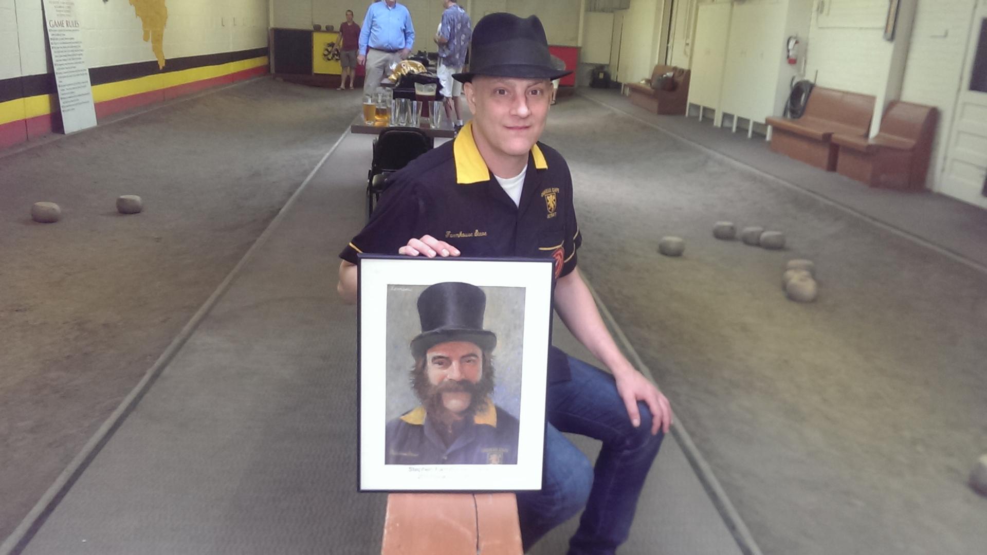Steve Gosskie, the 2013 Featherbowling chamption in the Cadieux Cafe. Gosskie holds the second portrait that Jerry Lemenu painted for him. The first was stolen and never returned.