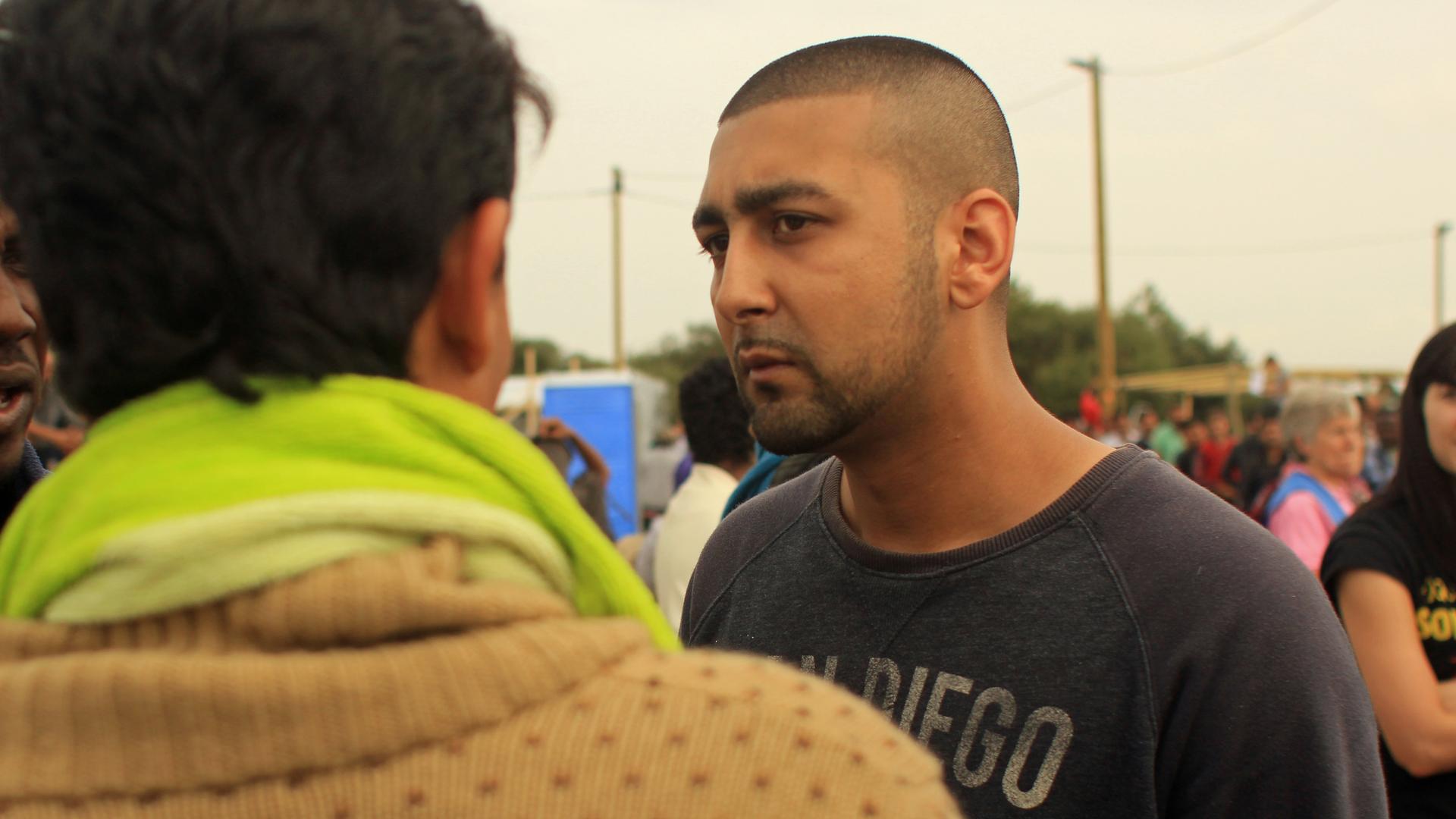 Syed Bokari talks to migrants at the 'Jungle' camp in Calais, France