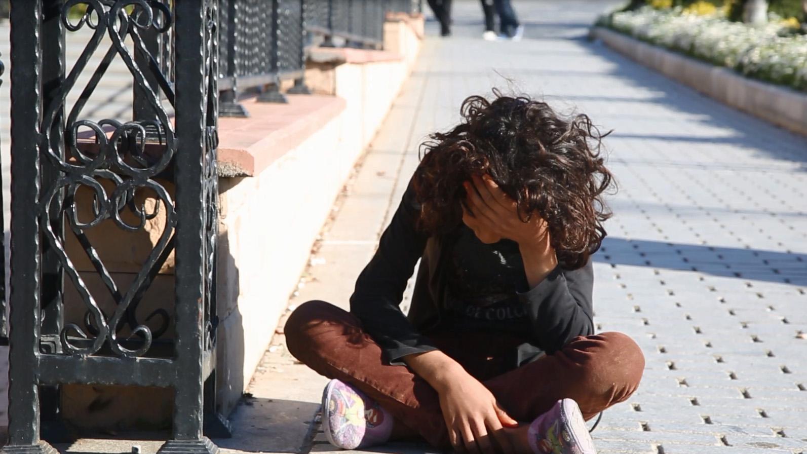 A Syrian refugee sits on the street in Istanbul.