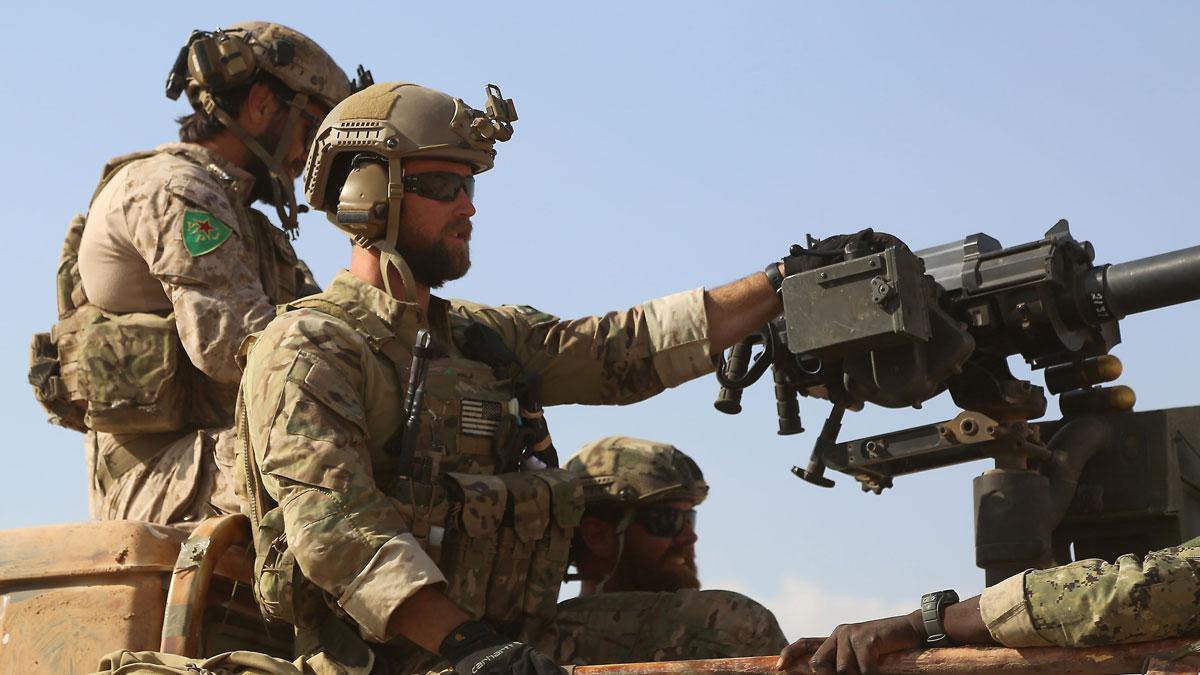 Armed men in uniform identified by Syrian Democratic forces as US Special Operations Forces ride in the back of a pickup in Fatisah in northern Syria on May 25.
