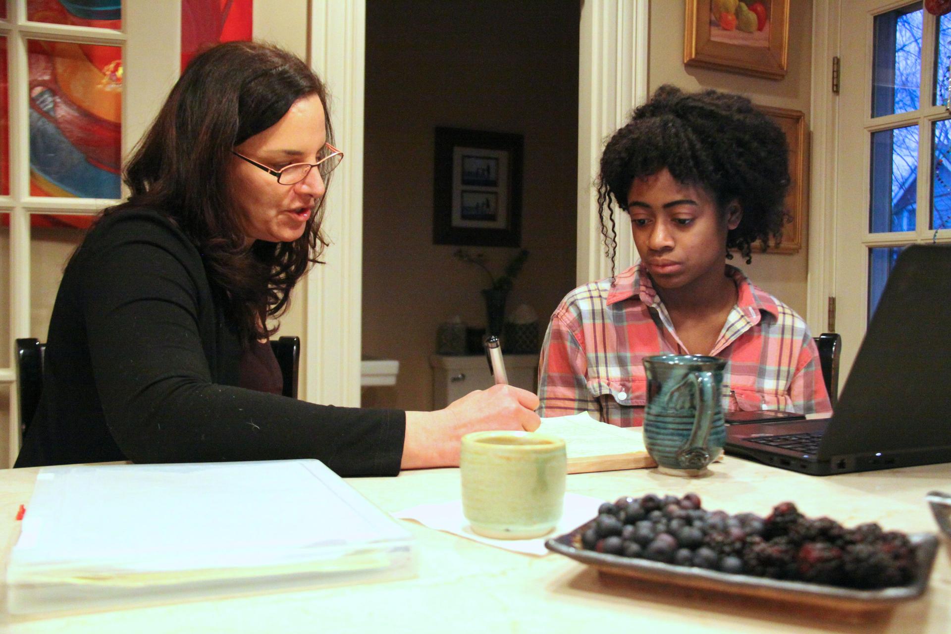 High school senior Mirabelle Espady and her mentor Marsha Kessler sit around the kitchen counter at Kessler’s home, reviewing Mirabelle’s college application.