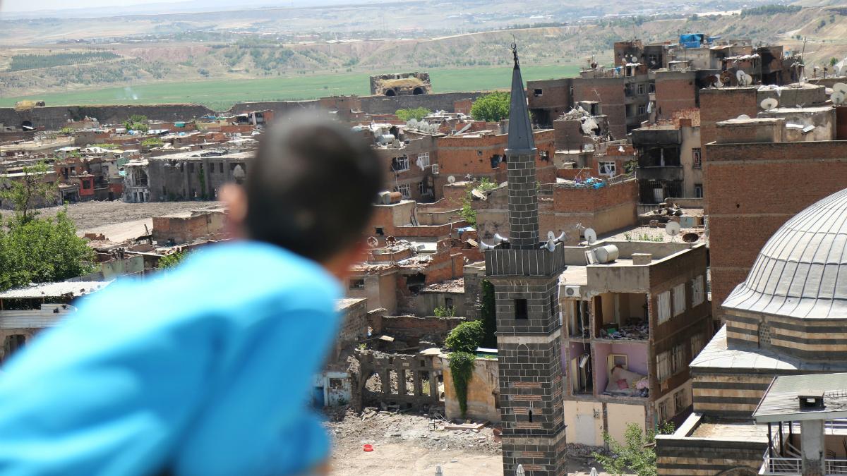 A boy looks at buildings which were damaged during clashes between Turkish security forces and Kurdish militants