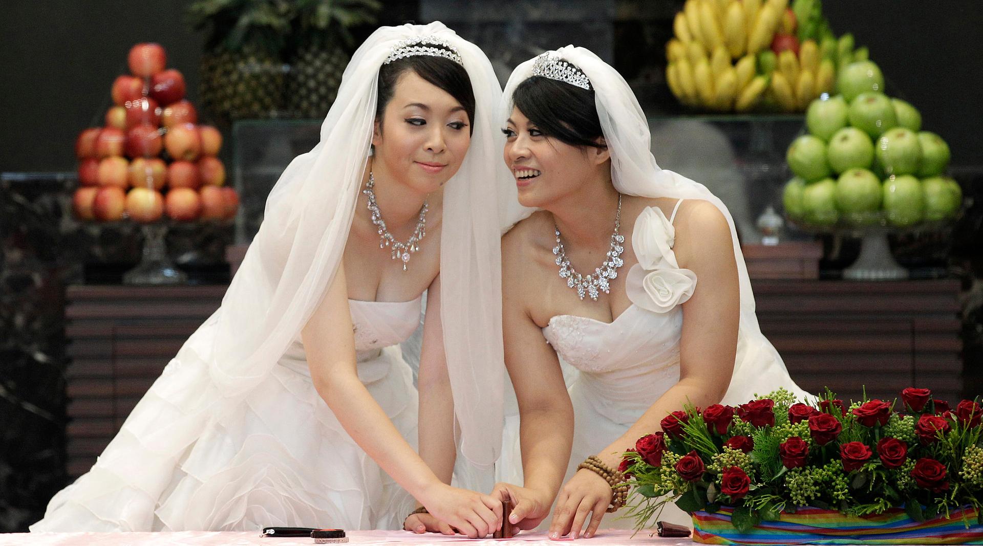 You Ya-ting, left, and Huang Mei-yu cast their stamps during their symbolic same-sex Buddhist wedding ceremony at a temple in Taoyuan county, northern Taiwan, on Aug. 11, 2012.