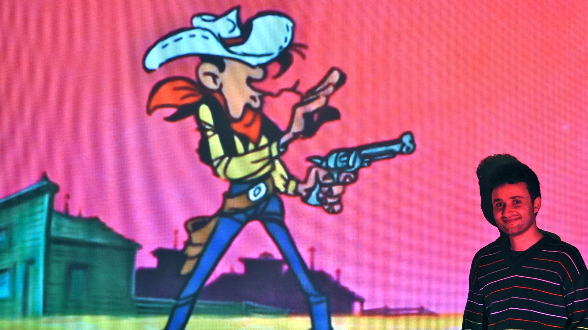 Reza Jamayran poses in front of an image of a childhood hero, Lucky Luke.
