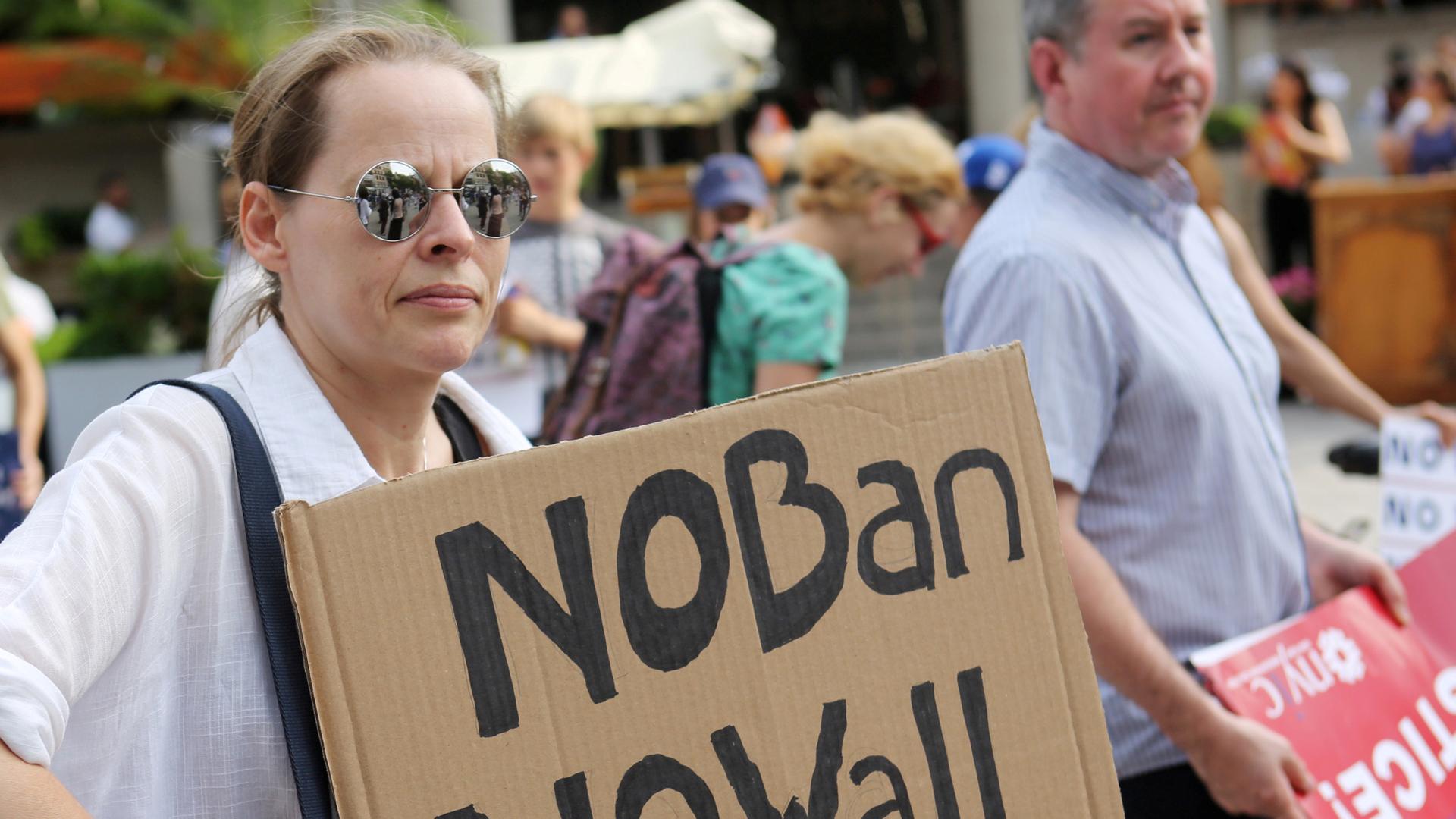 A protester holds a sign reading "No Ban, No Wall" at a protest against President Donald Trump's travel ban.