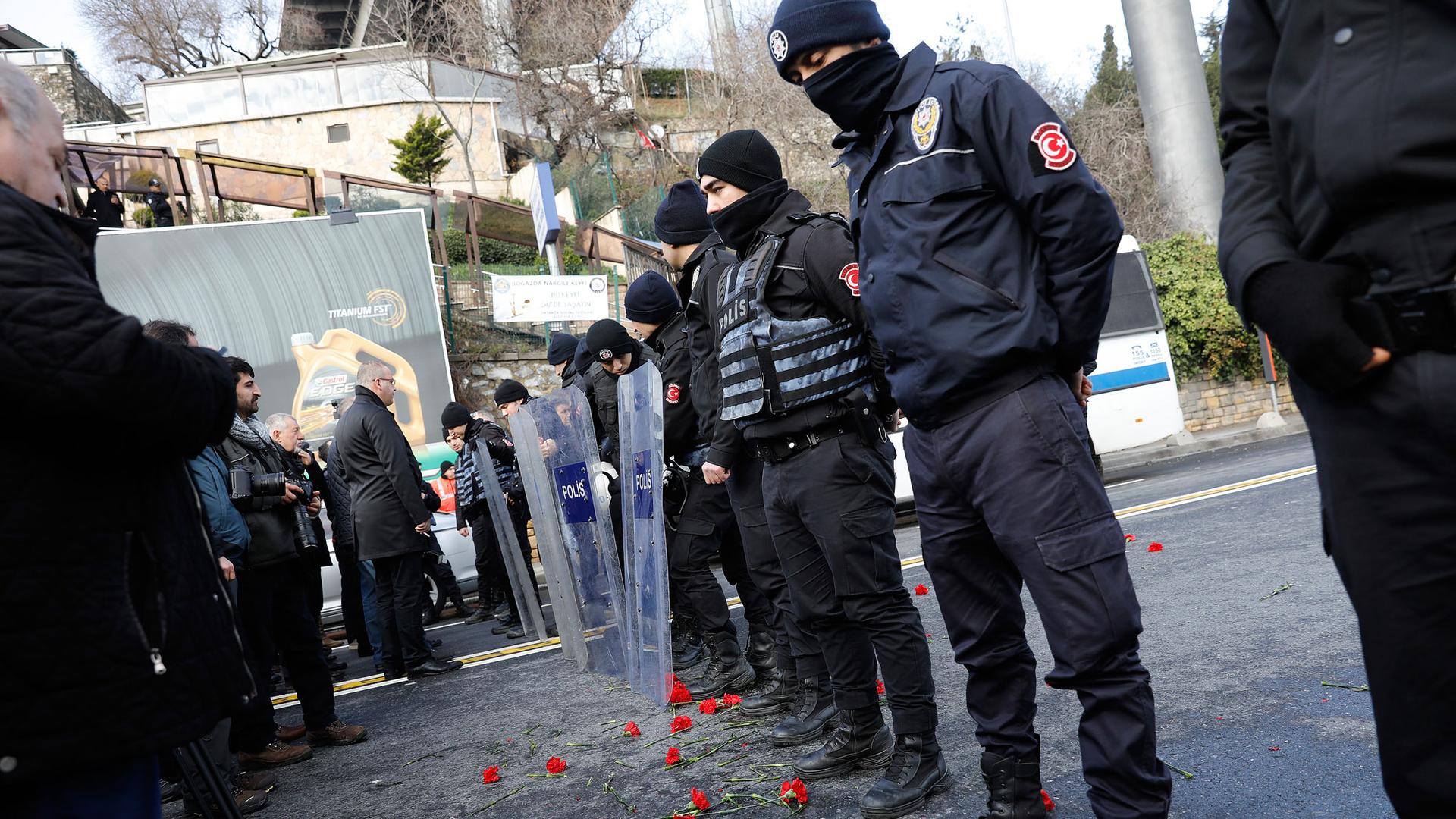 Flowers are placed next to Turkish police officers as they stand guard near the Reina nightclub, which was attacked by a gunman, in Istanbul, January 1.