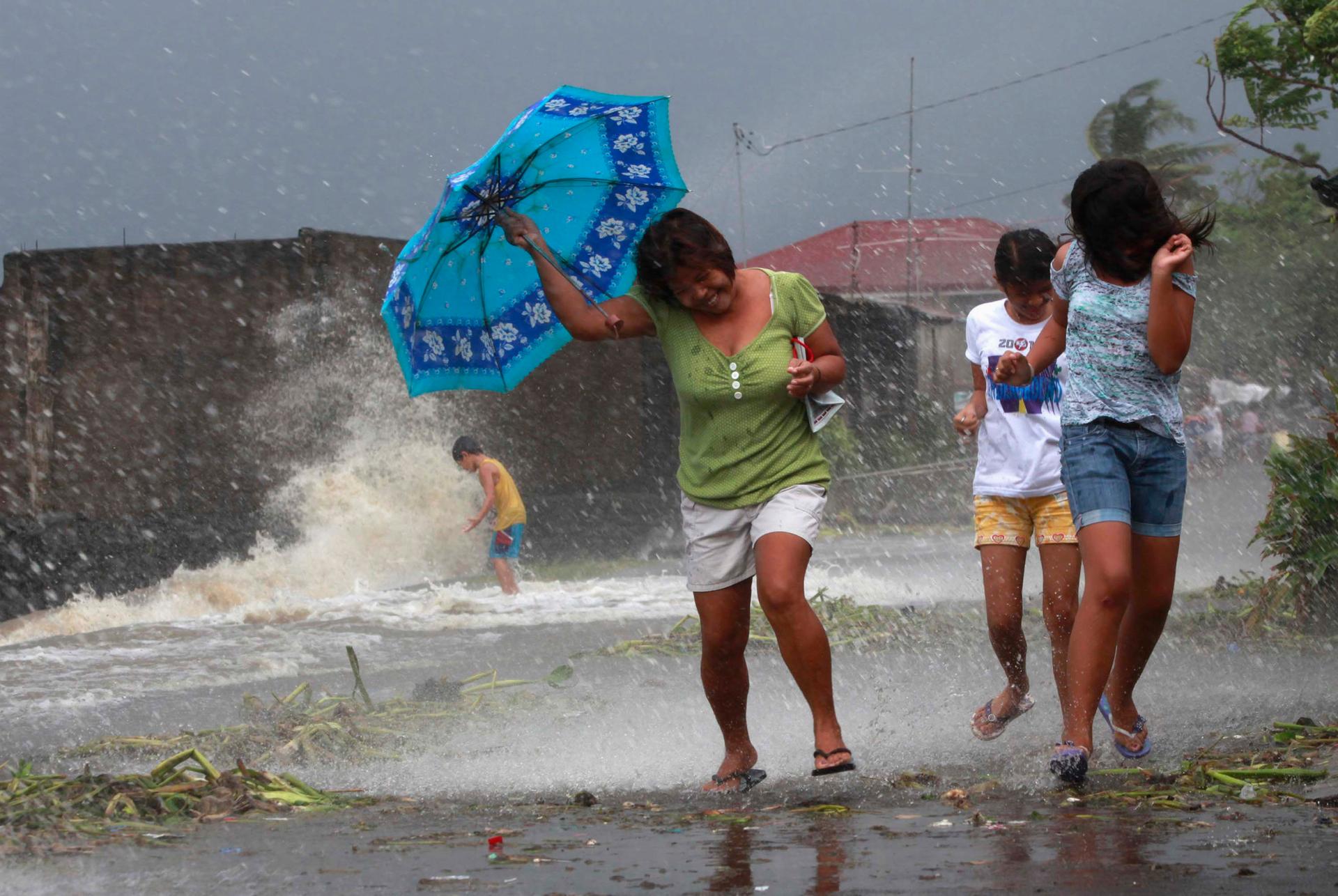 Residents walk along the coastal village while strong winds from Typhoon Haiyan battered Bayog town in Los Banos, Laguna, south of Manila November 8, 2013.