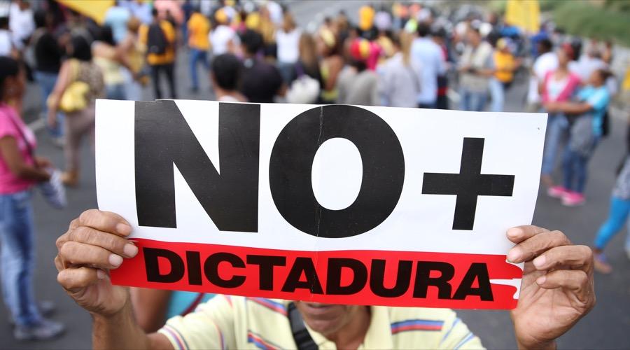 Venezuela opposition supporters hold a placard that reads "No more dictatorship"