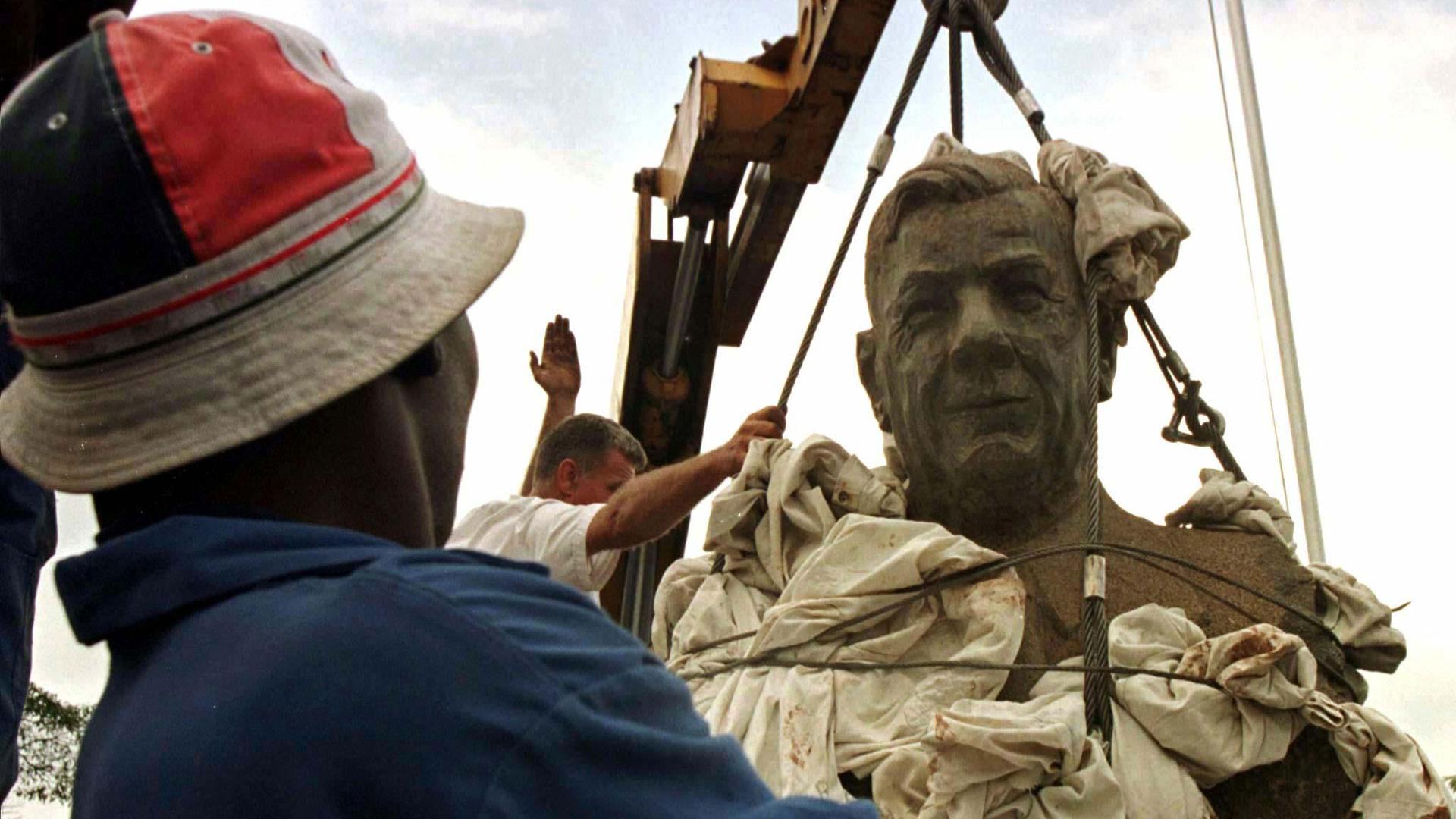 A man watches the bust of South Africa's Apartheid Architect, Hendrik Verwoerd, being removed from the entrance of Pretoria's main hospital named after him.