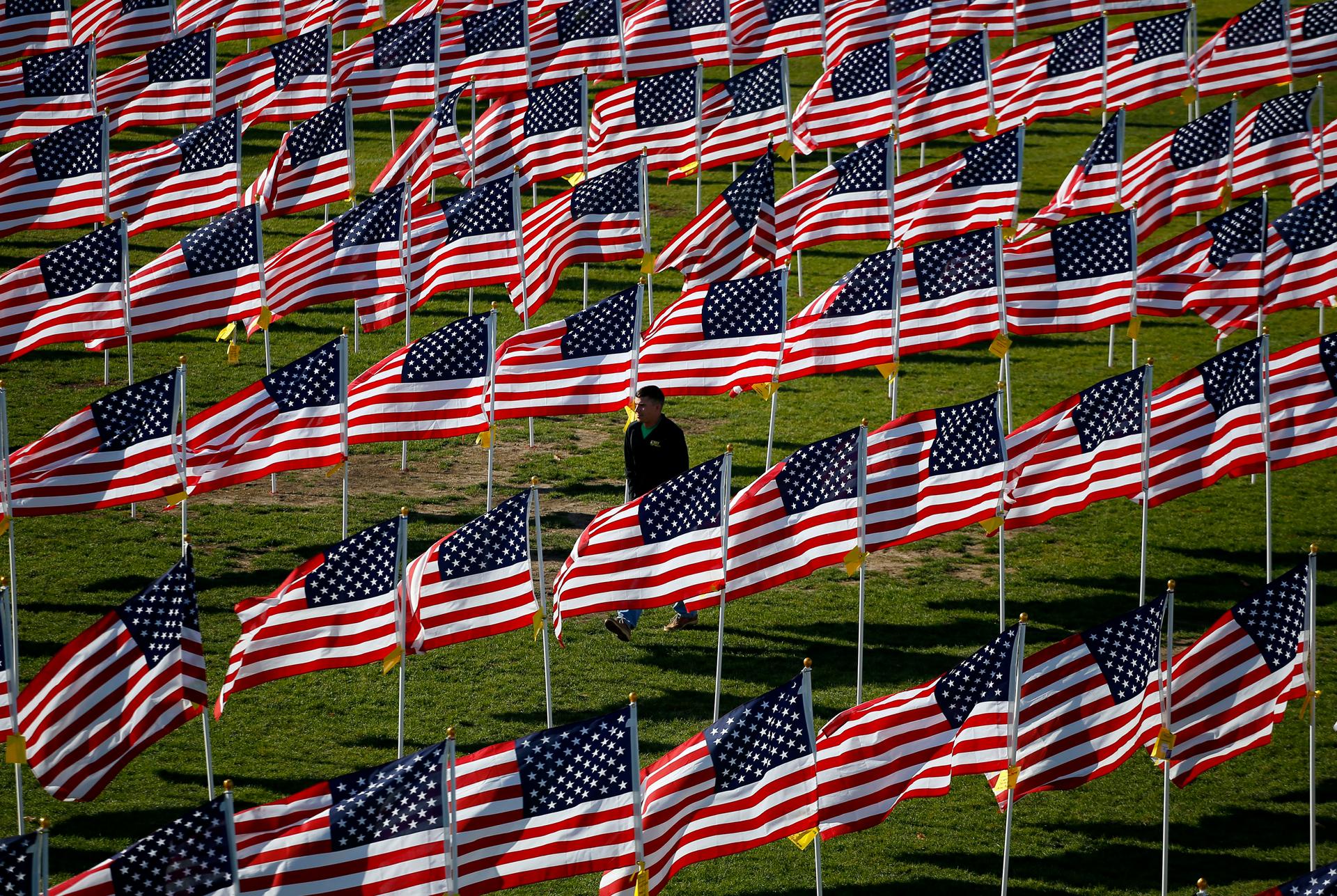 US Army serviceman Jason Richmond, of Batavia, Illinois, walks through some of the two thousand and thirteen United States flags that are part of the Aurora Healing Fields, to honor veterans.