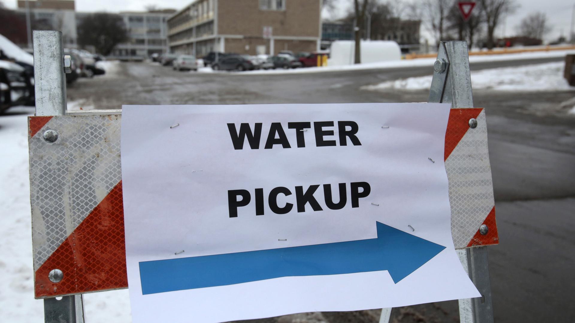 A "Water Pickup" sign points to a bottled water distribution center in Flint, Michigan in January. In an effort to save money, state officials running Flint's affairs implemented changes to the city's water system that resulted in widespread lead contamin