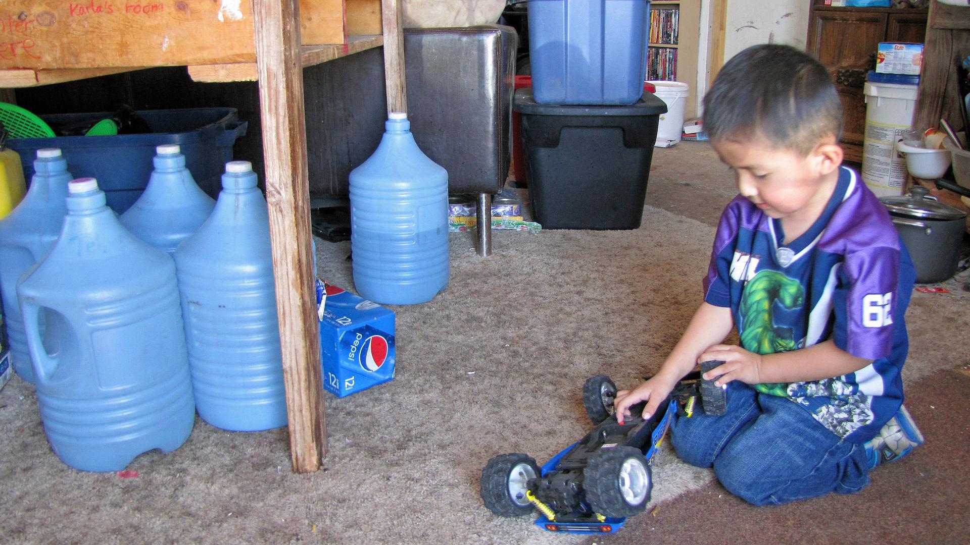 LaTanya Dickson's family has to travel 20 miles to get clean water, which they store in jugs under the kitchen table of their hogan on the Navajo Nation in northern Arizona.