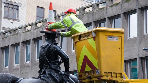 Removing the cone from the statue of the Duke of Wellington in Glasgow, Scotland