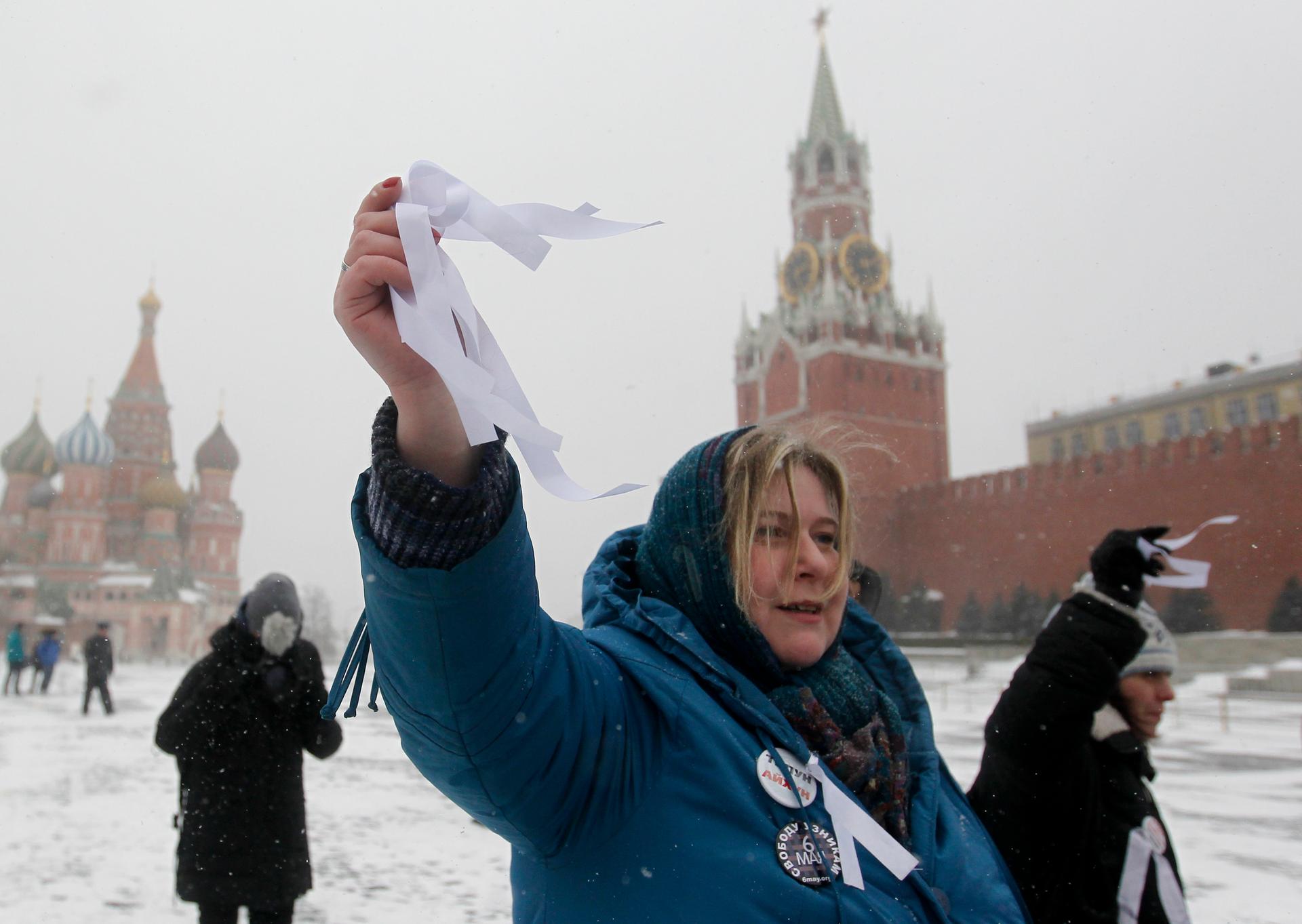 An activist holds white ribbons, the symbol of the opposition movement, during a protest  on Moscow's Red Square March 24, 2013. The action was organised to show solidarity for these arrested at opposition rallies in May 2012.