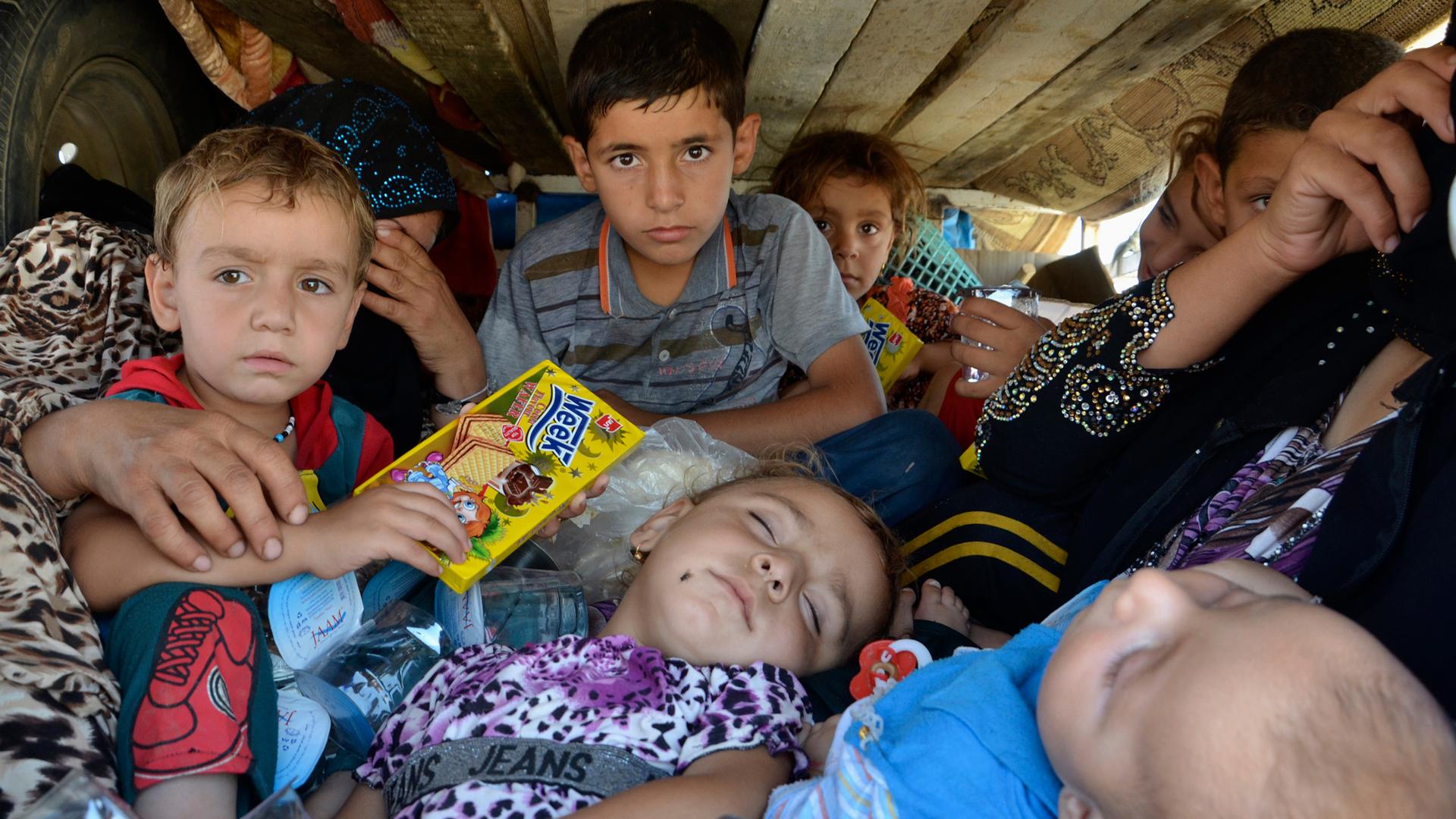 Displaced people, who fled from the violence in the province of Nineveh, arrive at Sulaimaniya province August 8, 2014. The United States began to drop relief supplies to beleaguered Yazidi refugees fleeing Islamist militants in Iraq, but there was no imm