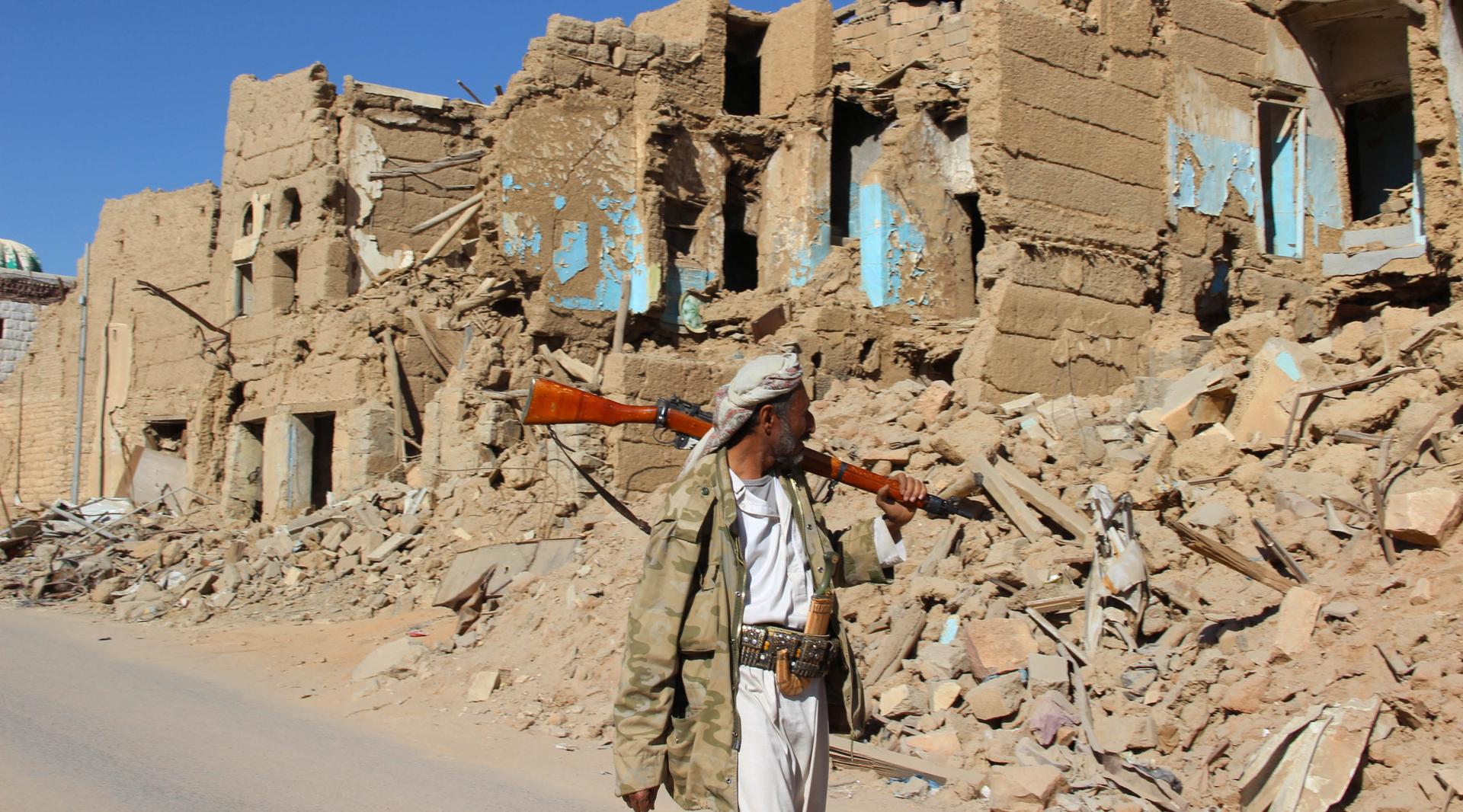 A Houthi armed man walks past destroyed houses in the old quarter of the northwestern city of Saada, Yemen, on Jan. 11.