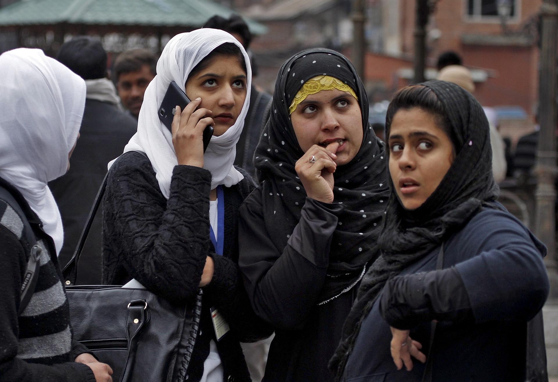 Kashmiri girls stand on a roadside