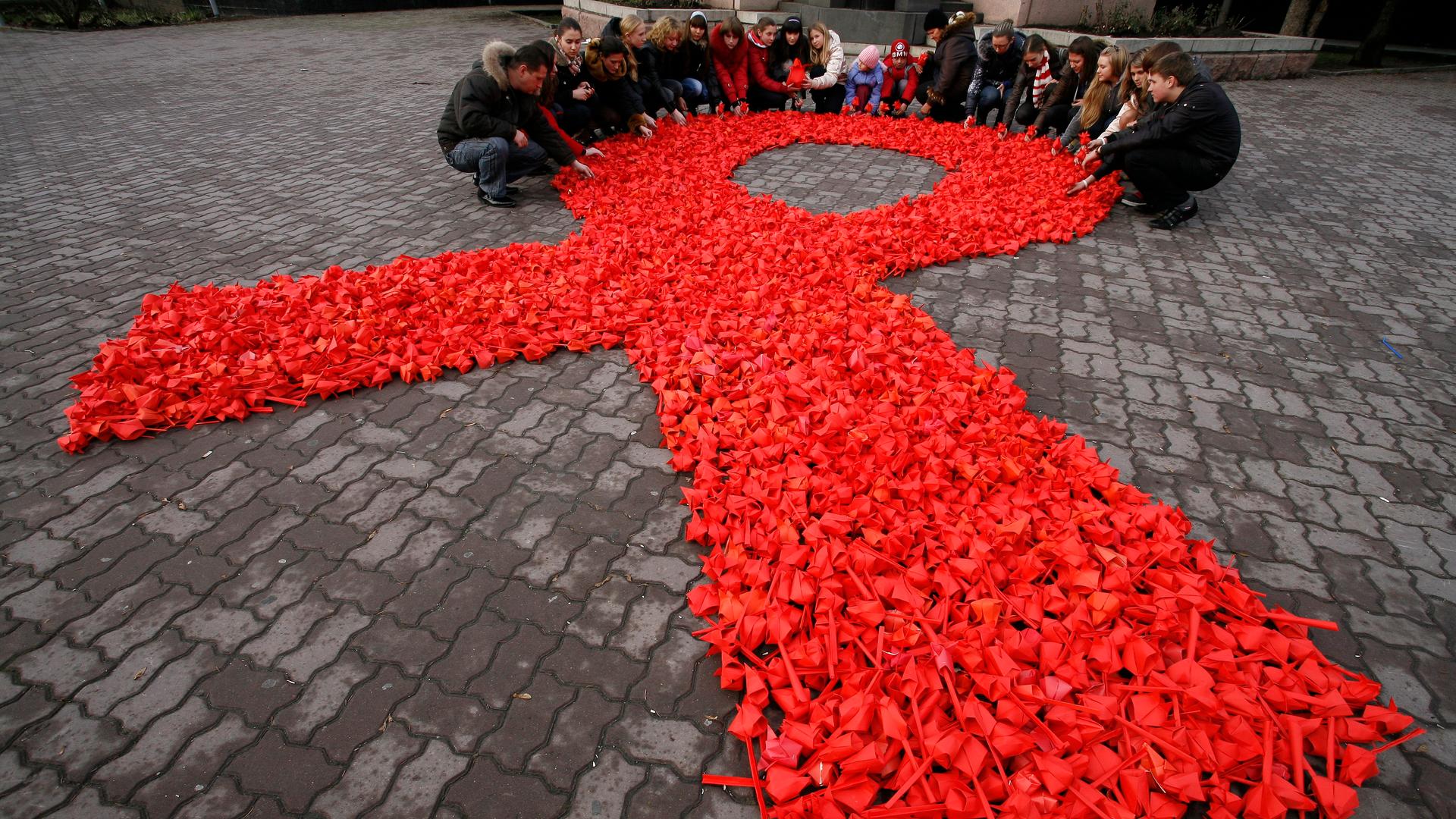Activists of the "Young Medics of Russia" social organization and city volunteers form a red ribbon