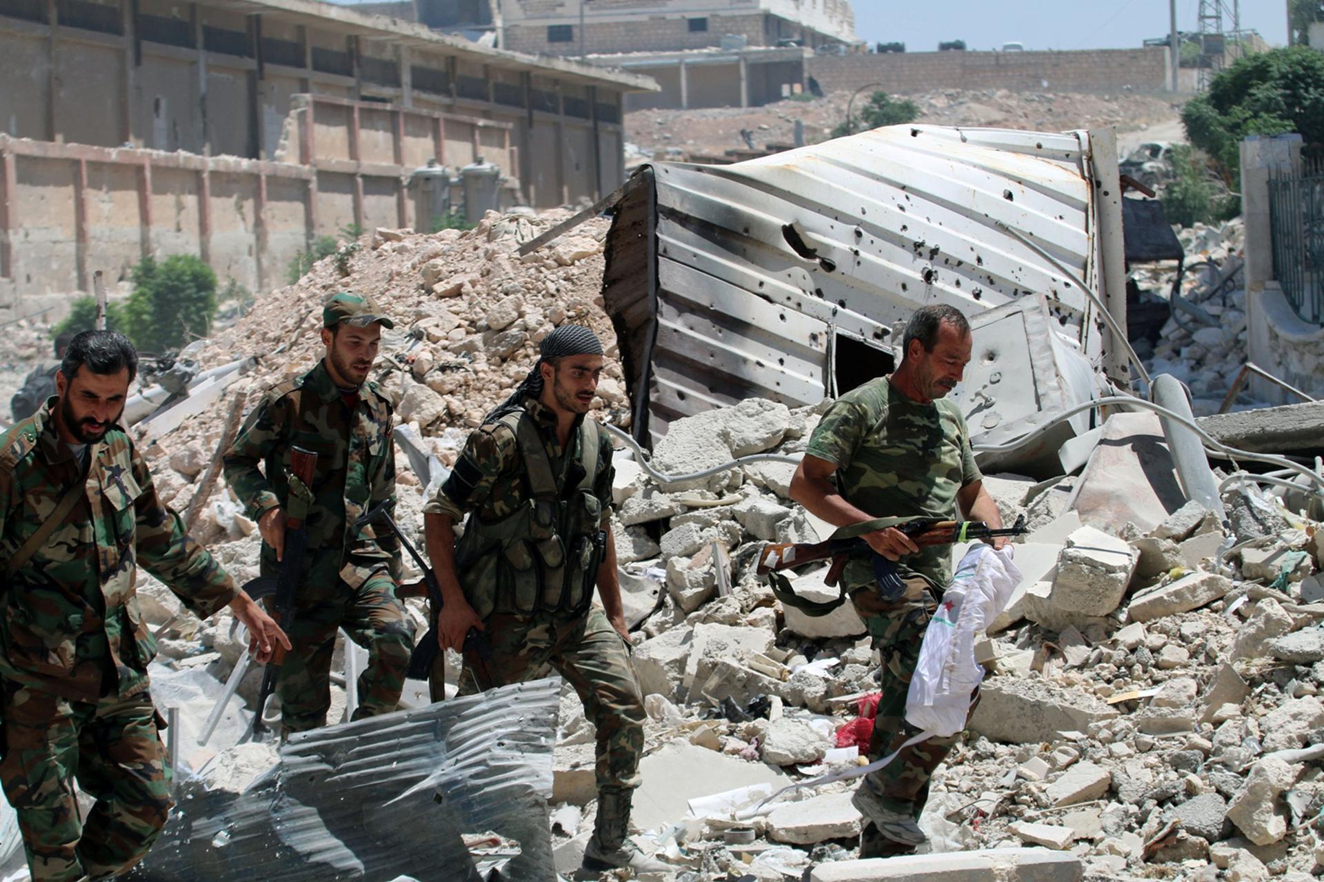 Forces loyal to Syria's President Bashar al-Assad walk through rubble after they advanced on the southern side of the Castello road in Aleppo, Syria, in this handout picture provided by SANA on July 28, 2016.