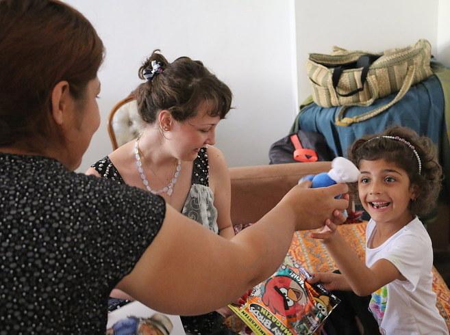 A Syrian child receives a toy in the home a Berlin resident. 