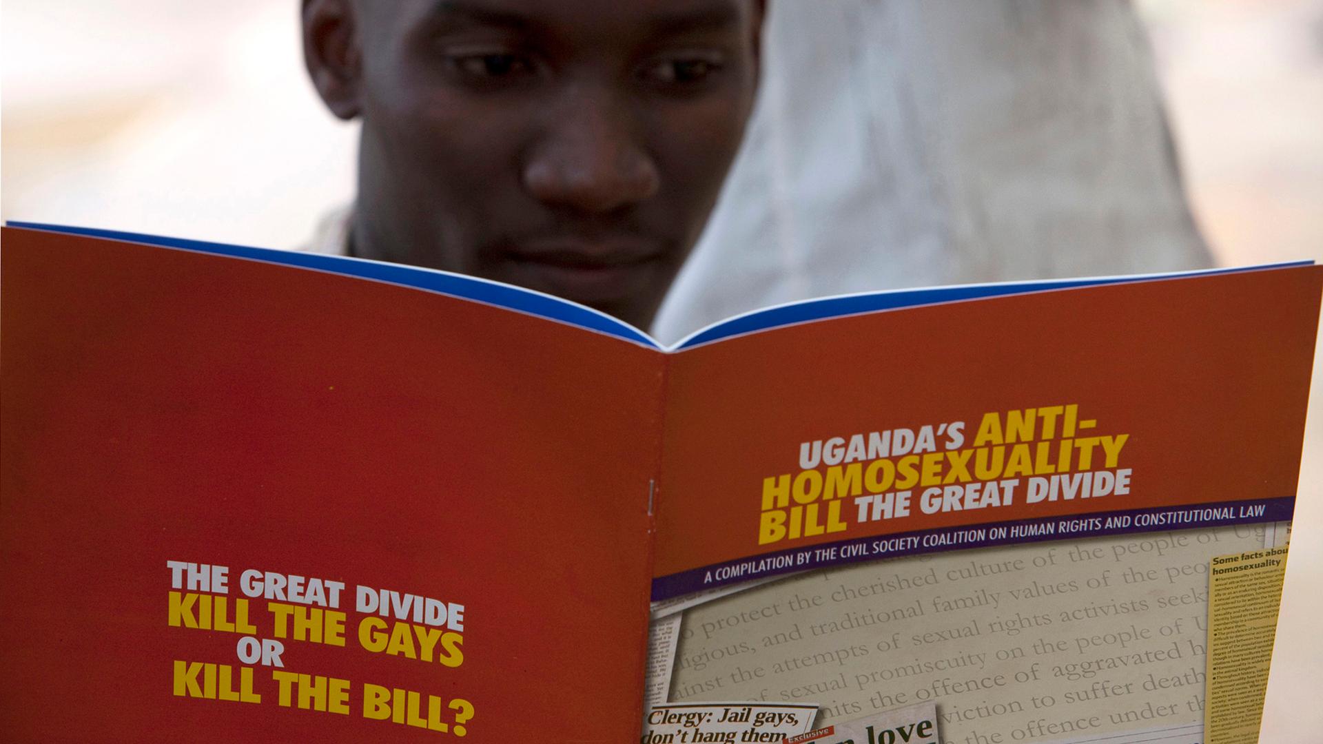 A man reads a publication by a civil society coalition on human rights and constitutional law in Kampala.
