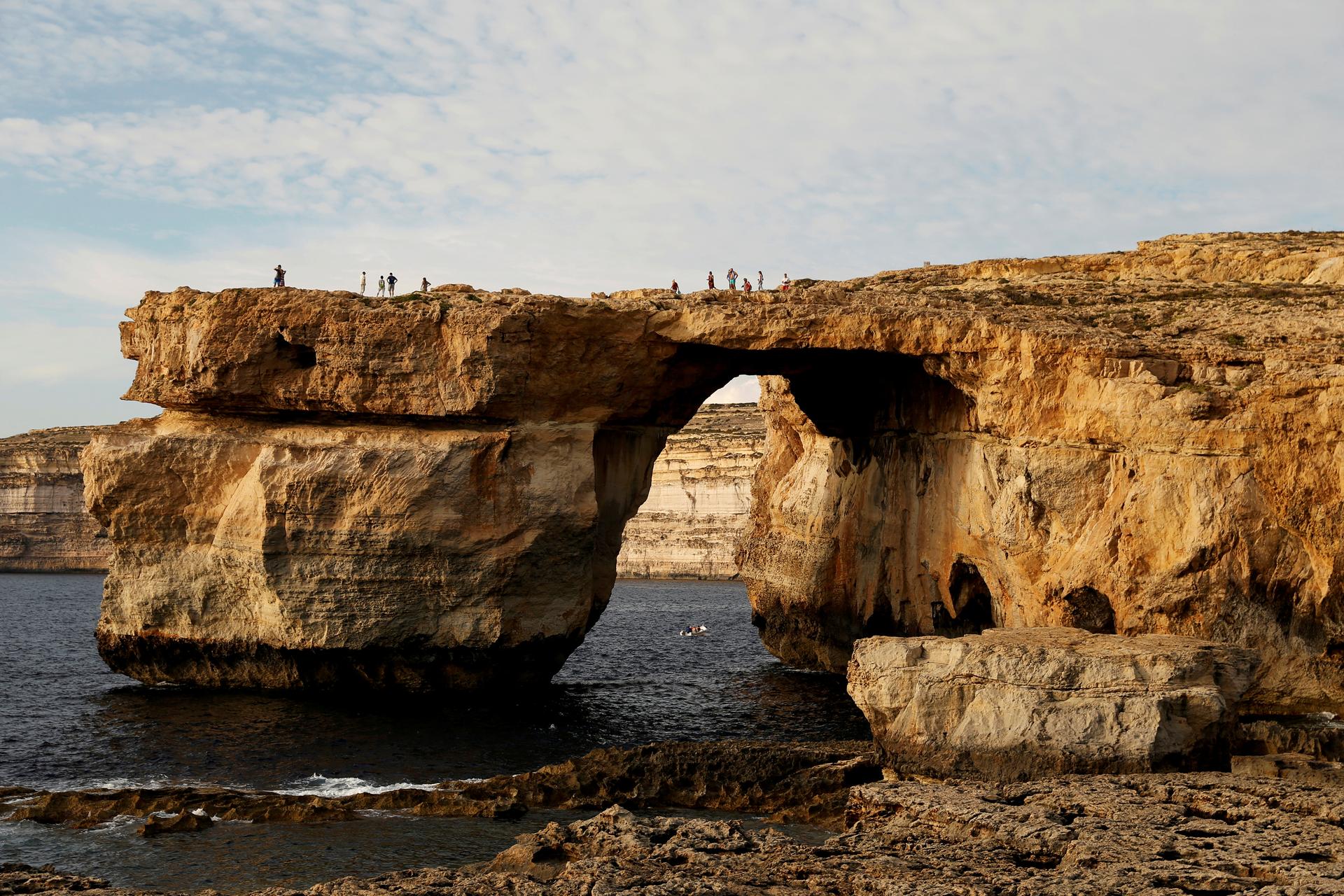 Tourists walk on the Azure Window, a 50 metre high rock arch, at Dwejra Point cliffs on the west coast of the Maltese island of Gozo September 23, 2016.