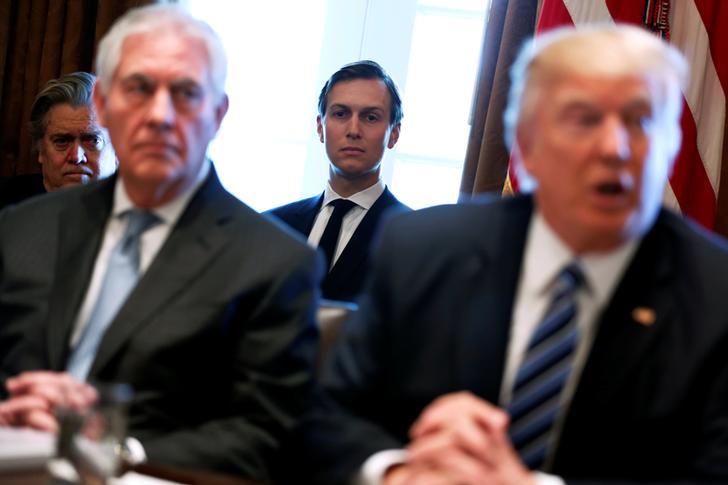 Secretary of State Rex Tillerson and President Donald Trump appear in a blurry photograph during a cabinet meeting. White House advisors Steve Bannon and Jared Kushner look on in the background. 
