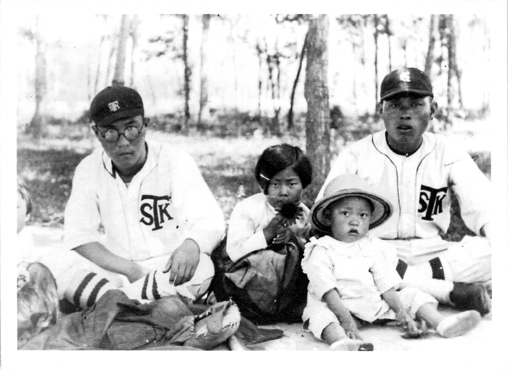 No Kum Sok, age 3, wearsing a pith helmet, with his father, No Zae Hiub (right), an all-star pitcher for his company’s baseball team, in Sinhung, Korea, in 1935.