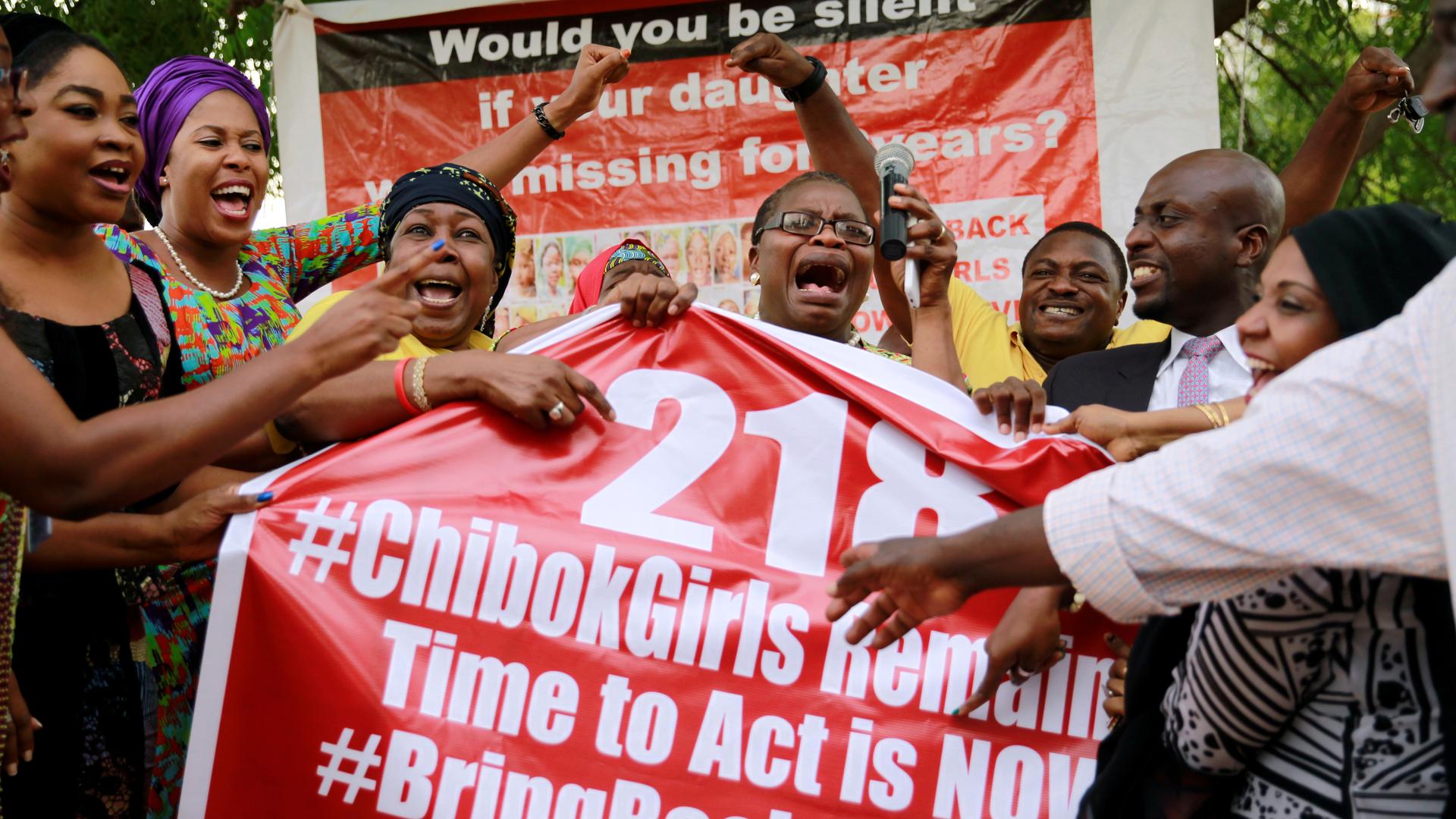 Members of the #BringBackOurGirls campaign react on the presentation of a banner referring to the kidnapped Chibok school girls, during a sit-out in Abuja, Nigeria May 18, 2016, 