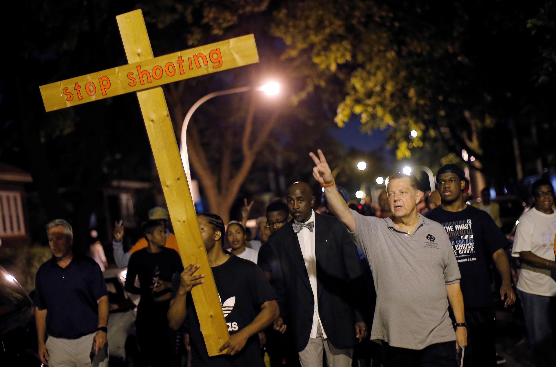 Father Michael Pfleger marches through the streets of a South Side neighborhood during a weekly night-time peace demonstration in Chicago, Illinois, September 16, 2016.