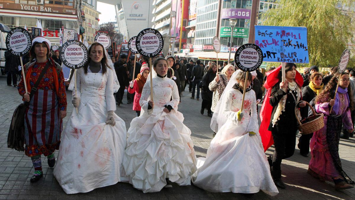 Women activists, some dressed in wedding gowns representing child brides forced into marriage, hold placards that read "End violence" to protest rape and domestic violence, in Ankara, Turkey. November, 2011.