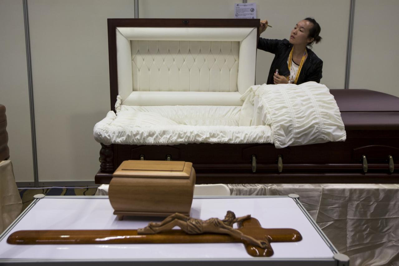 A exhibitor mends a coffin during the Asia Funeral and Cemetery Expo in Macau on May 8, 2014.