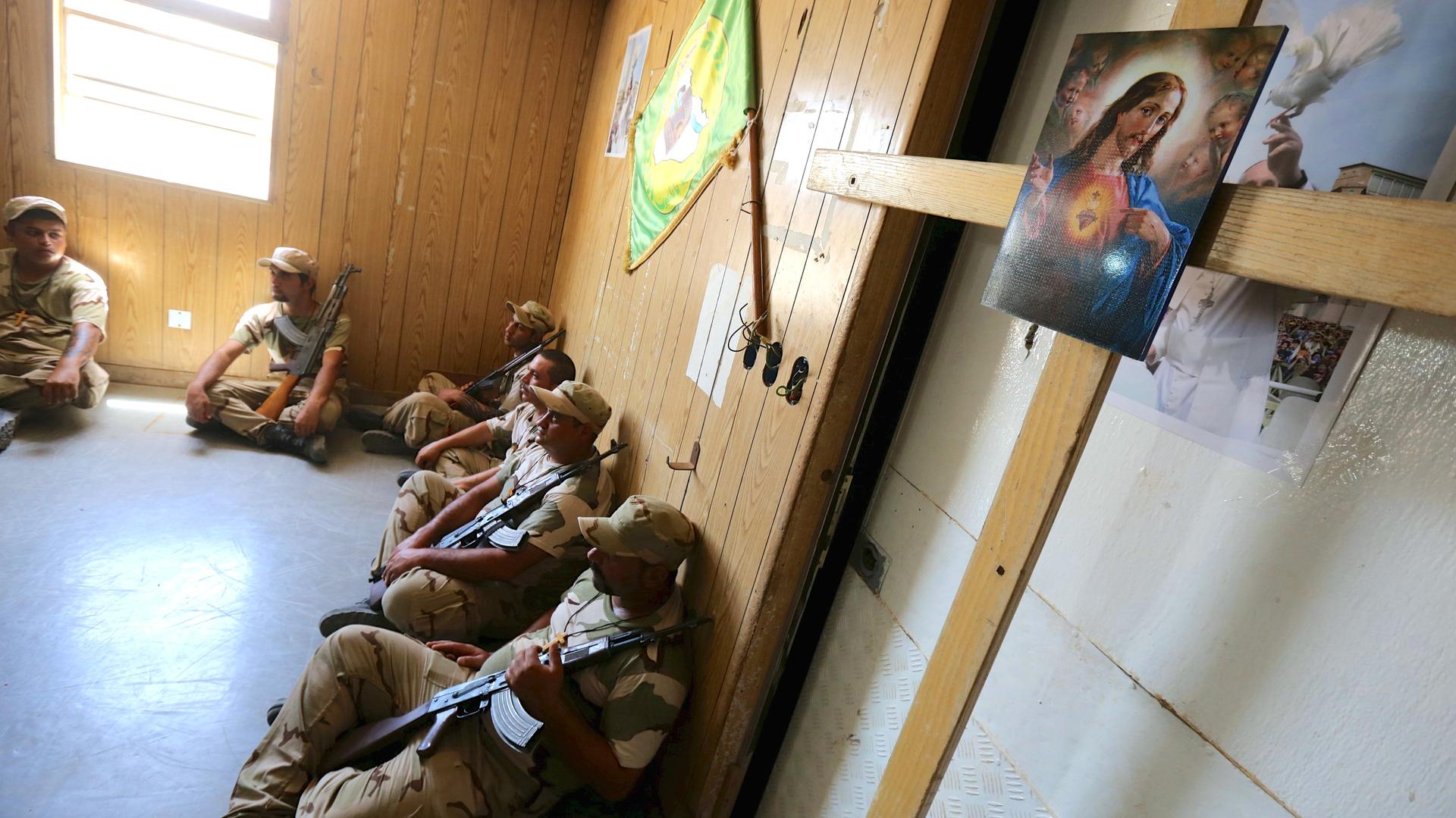 Iraqi Christian volunteers, part of a militia allied with Iraqi military forces against the extremists of ISIS, take a rest during training in a military camp in Baghdad on July 1, 2015.