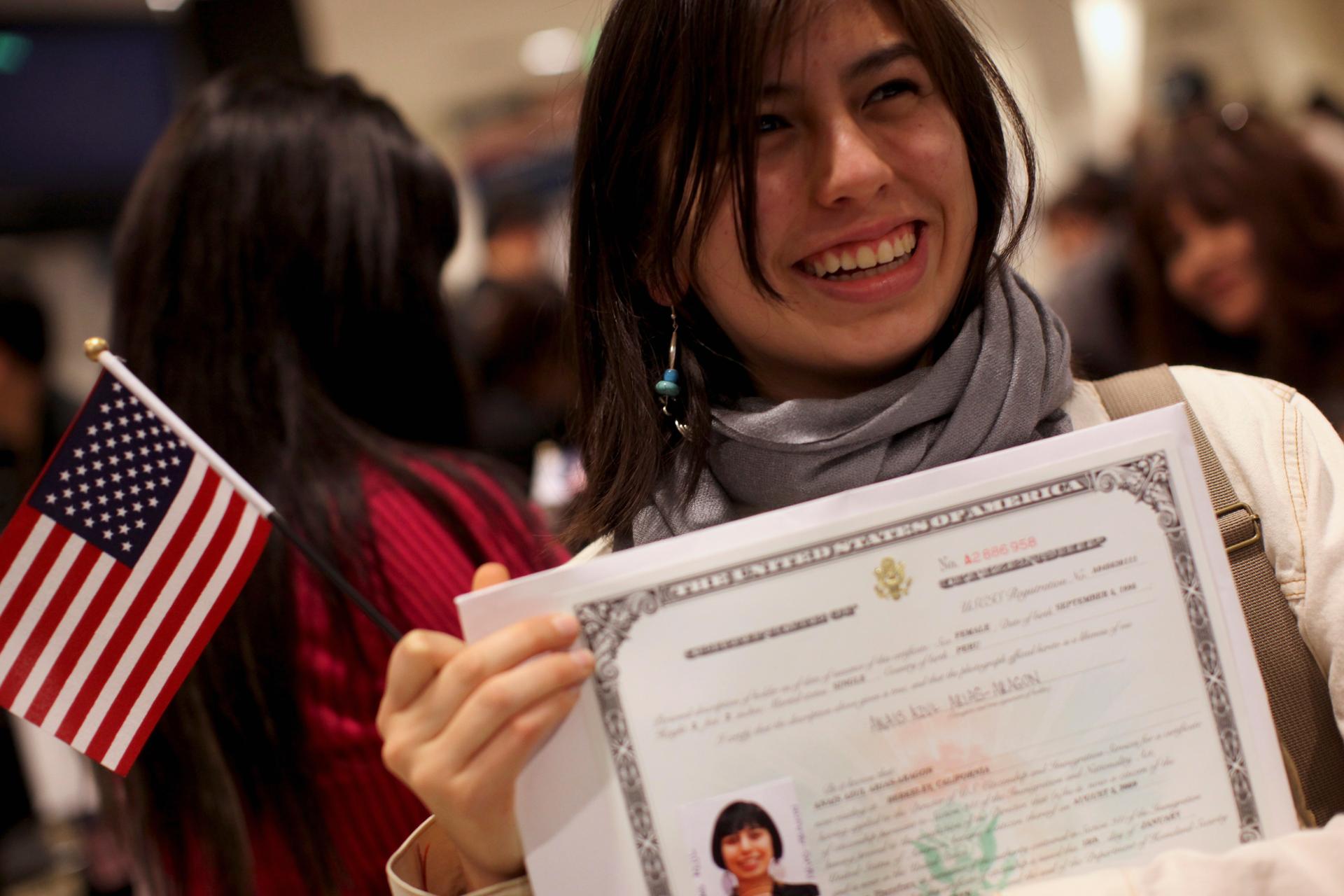 Anais Arias-Aragon poses for pictures with her certificate after receiving proof of U.S. citizenship